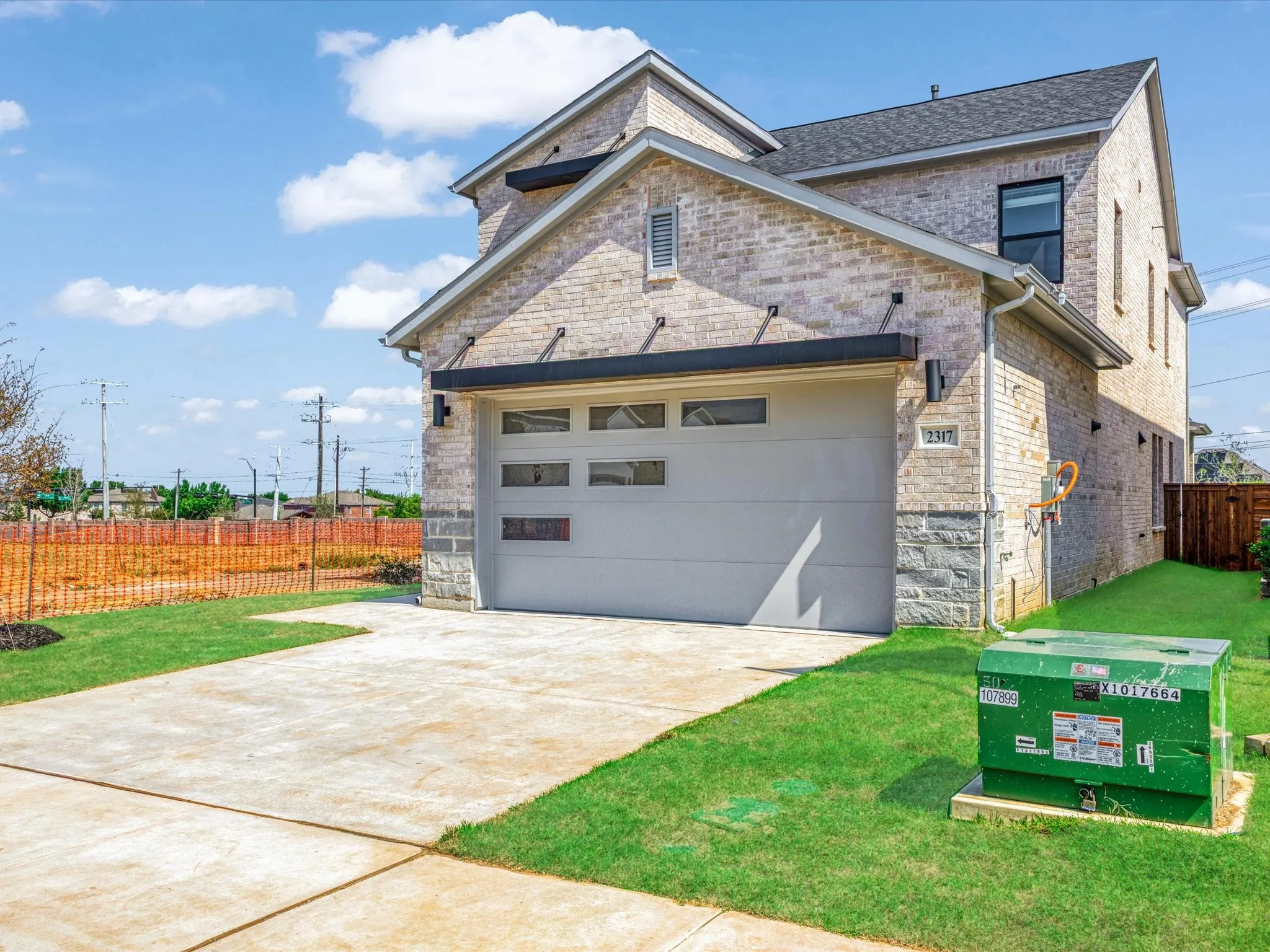 View of front of home featuring concrete driveway, an attached garage, brick siding, and roof with shingles