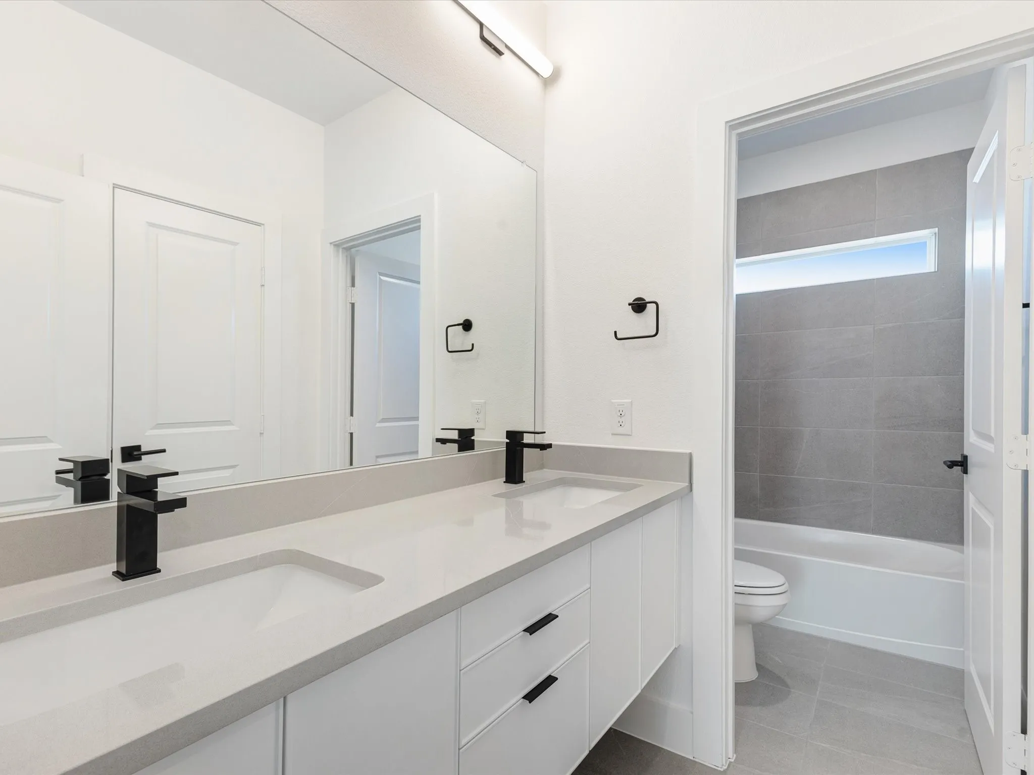 Bathroom featuring light tile patterned floors and washtub / shower combination
