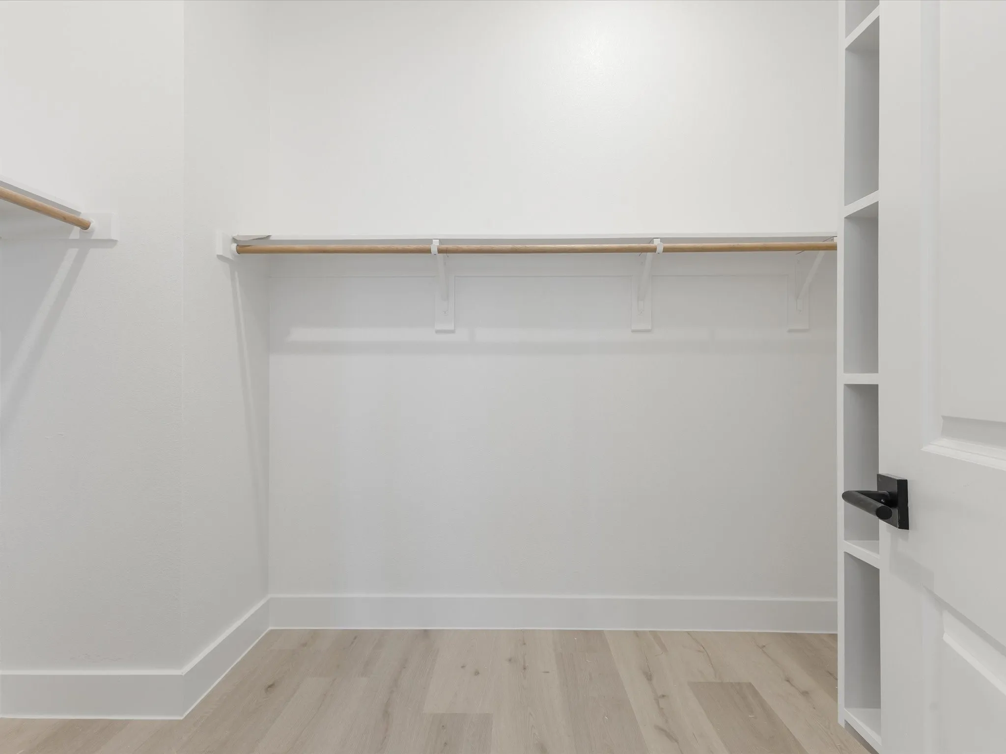 Primary closet with light wood-type flooring