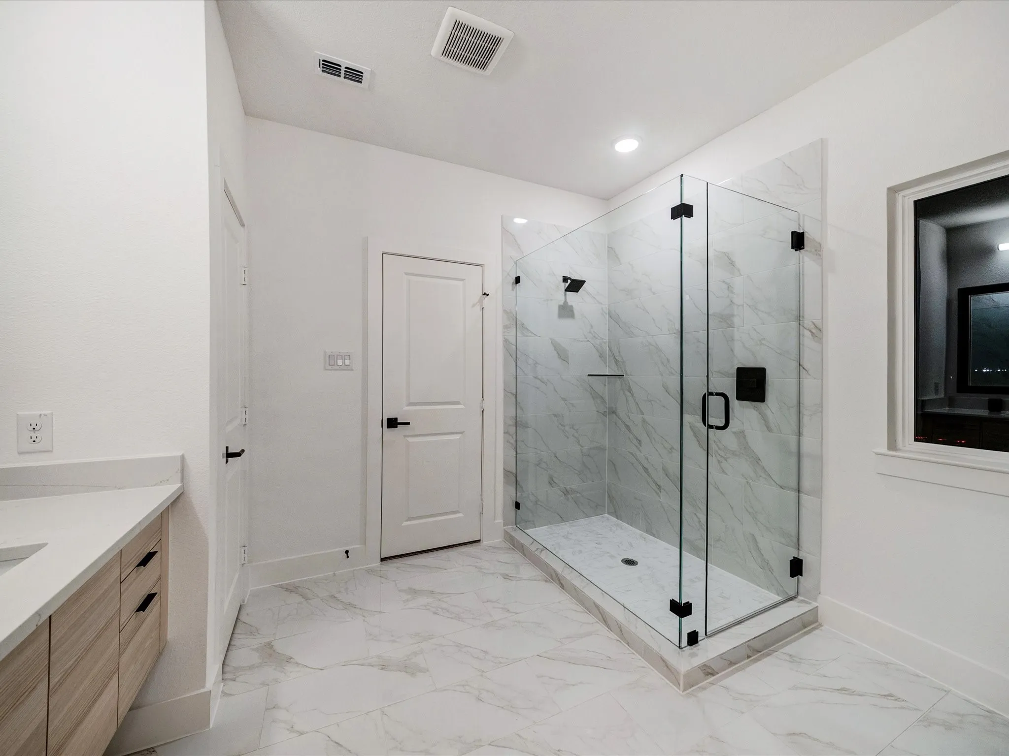 Full bathroom with a marble finish shower, vanity, and light marble finish flooring