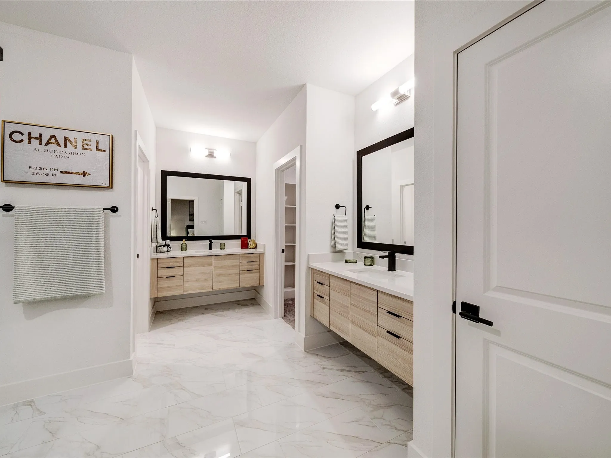 Bathroom featuring two vanities and light marble finish floors