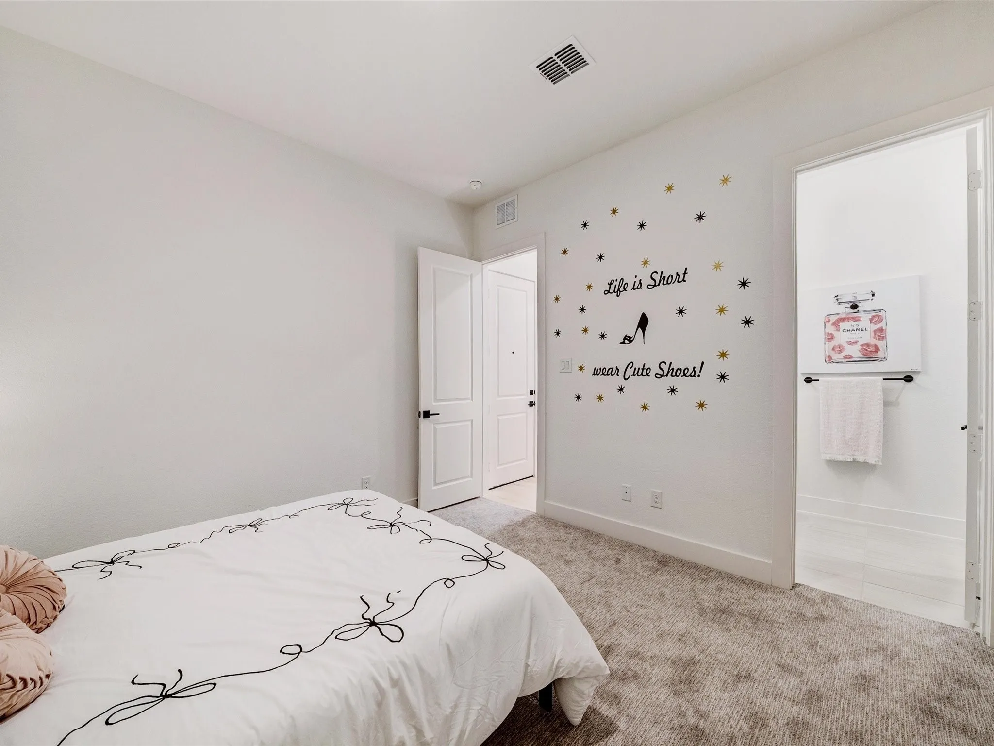 Bedroom featuring light carpet and connected bathroom