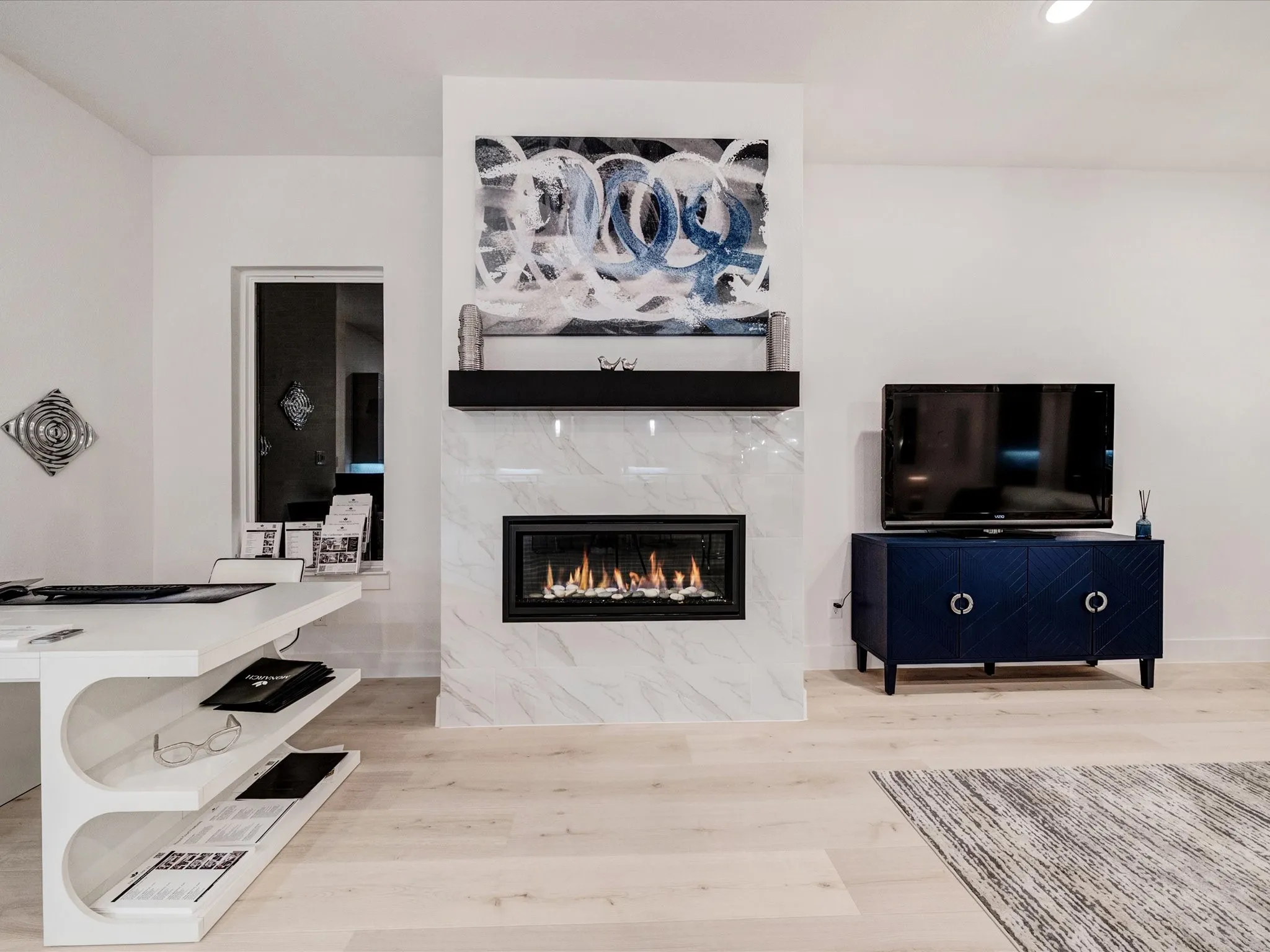 Living room featuring a high end fireplace, light wood-style floors, and recessed lighting
