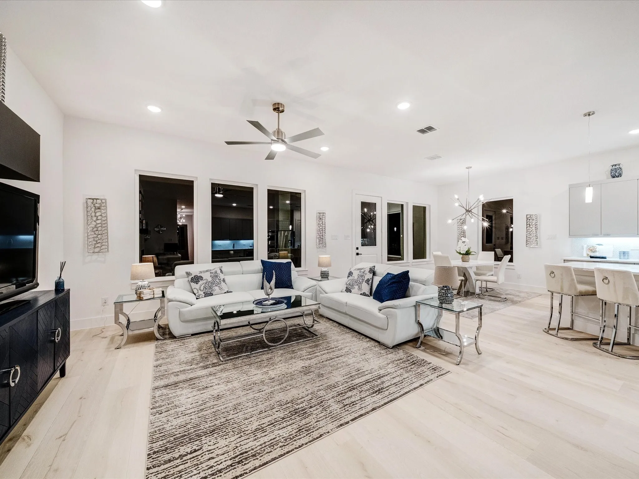 Living area featuring recessed lighting, ceiling fan, light wood finished floors, and a chandelier