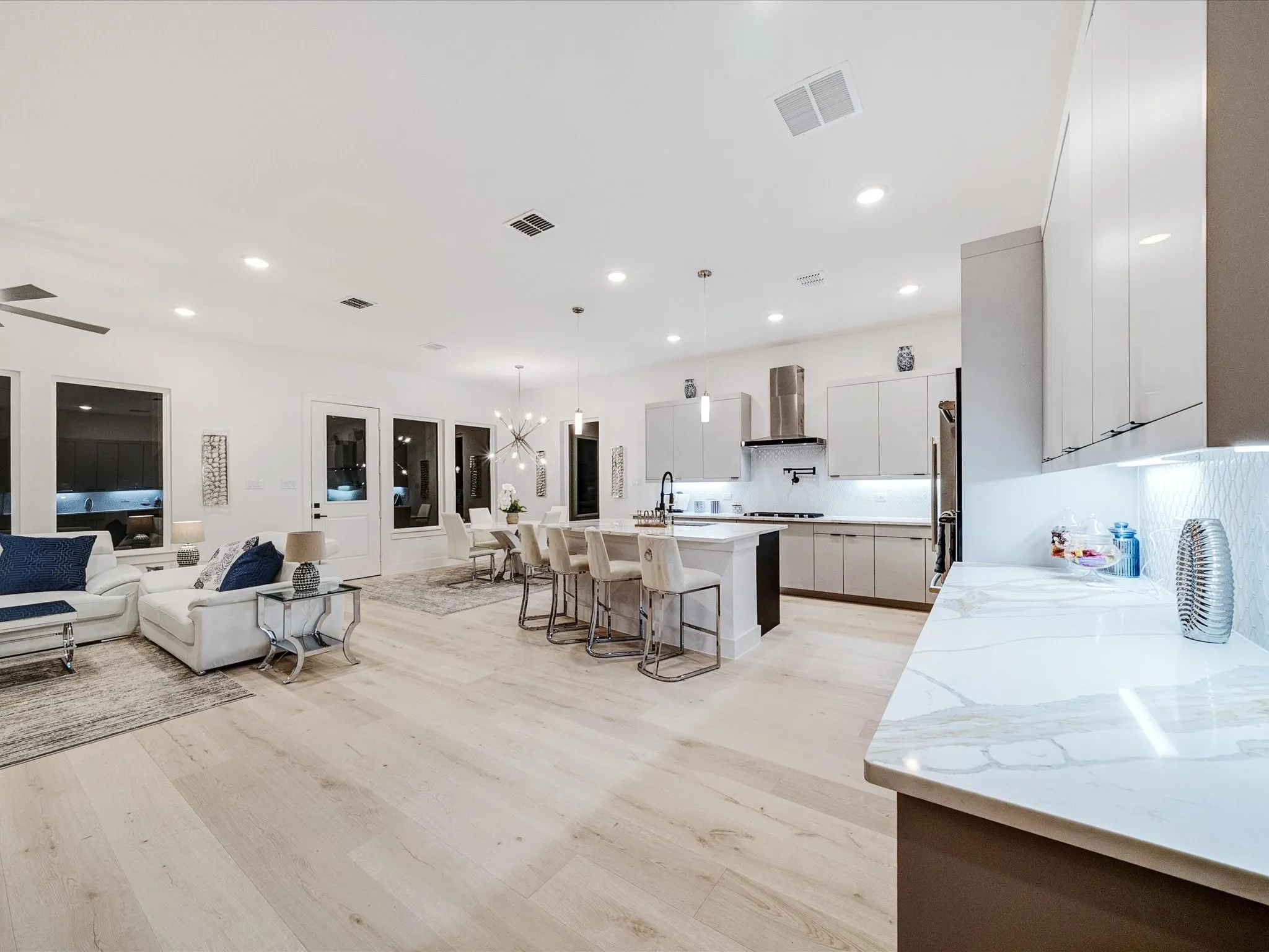 Kitchen featuring a breakfast bar, a chandelier, open floor plan, a kitchen island with sink, and hanging light fixtures