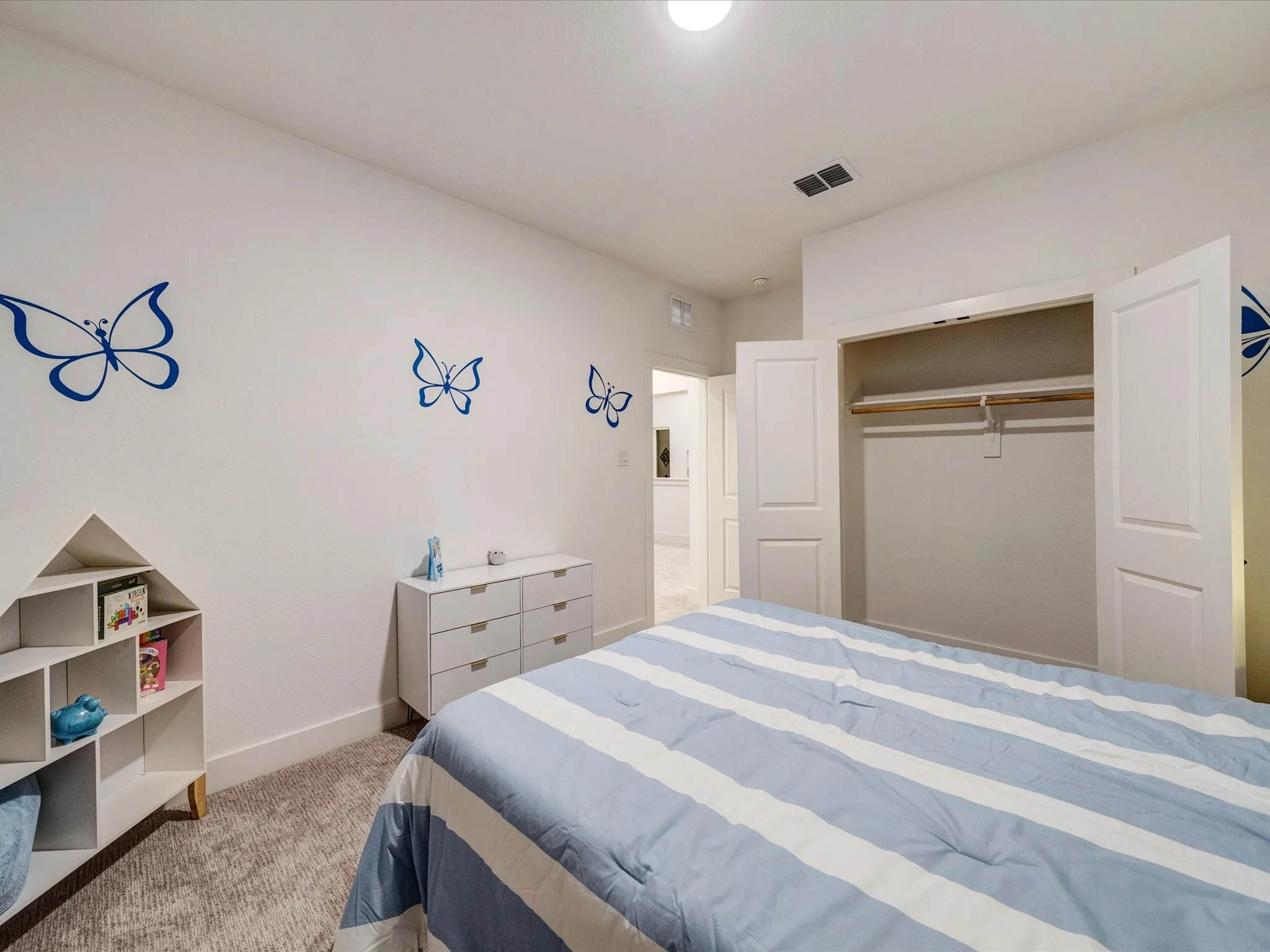Bedroom with light colored carpet and a closet