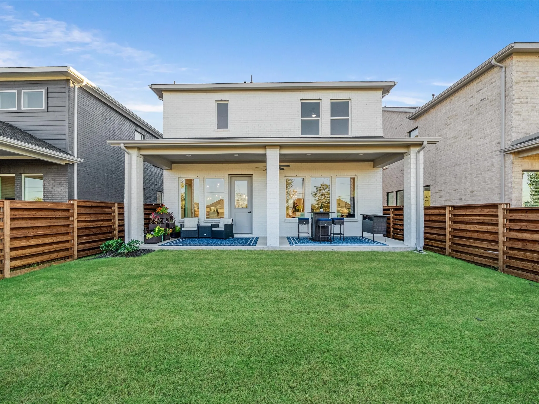 Back of property featuring a patio, brick siding, and a fenced backyard