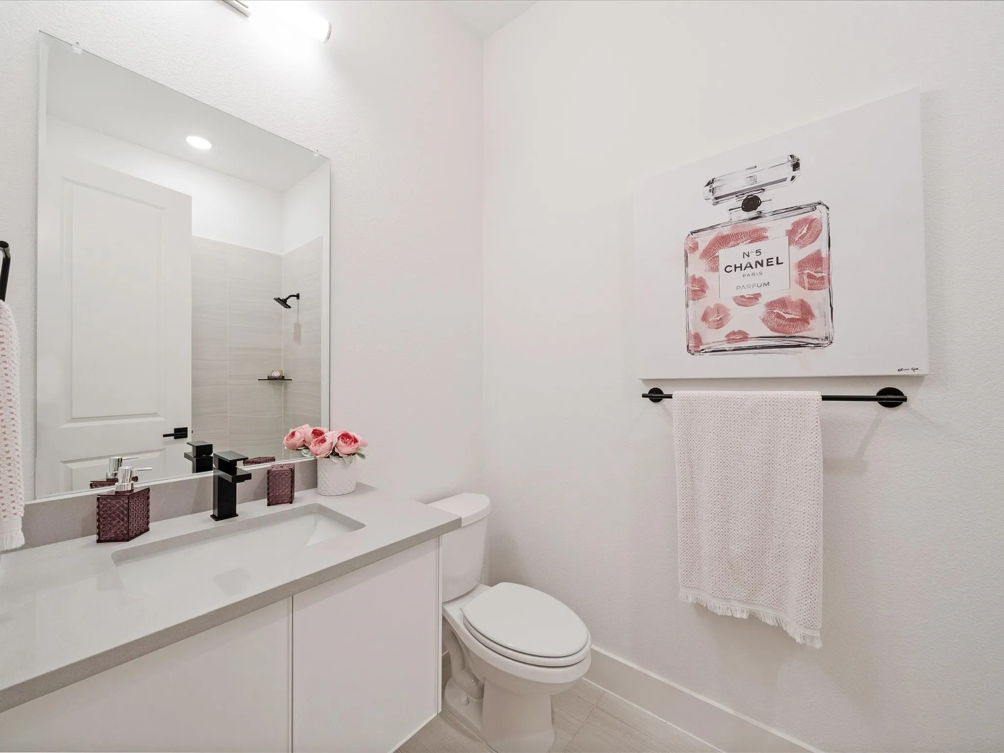 Full bath featuring vanity, tiled shower, and light tile patterned floors