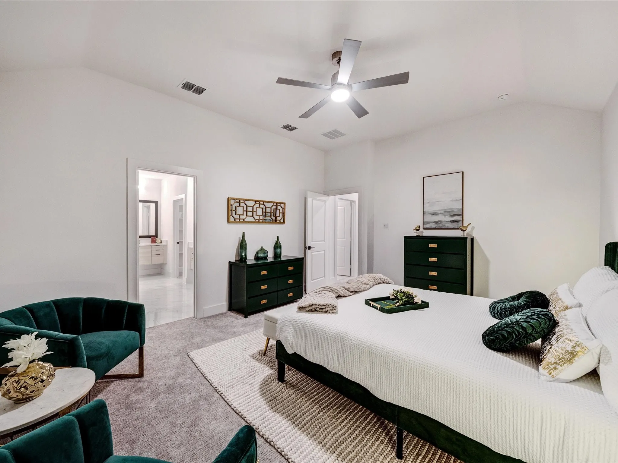 Carpeted bedroom with vaulted ceiling, ceiling fan, and ensuite bathroom