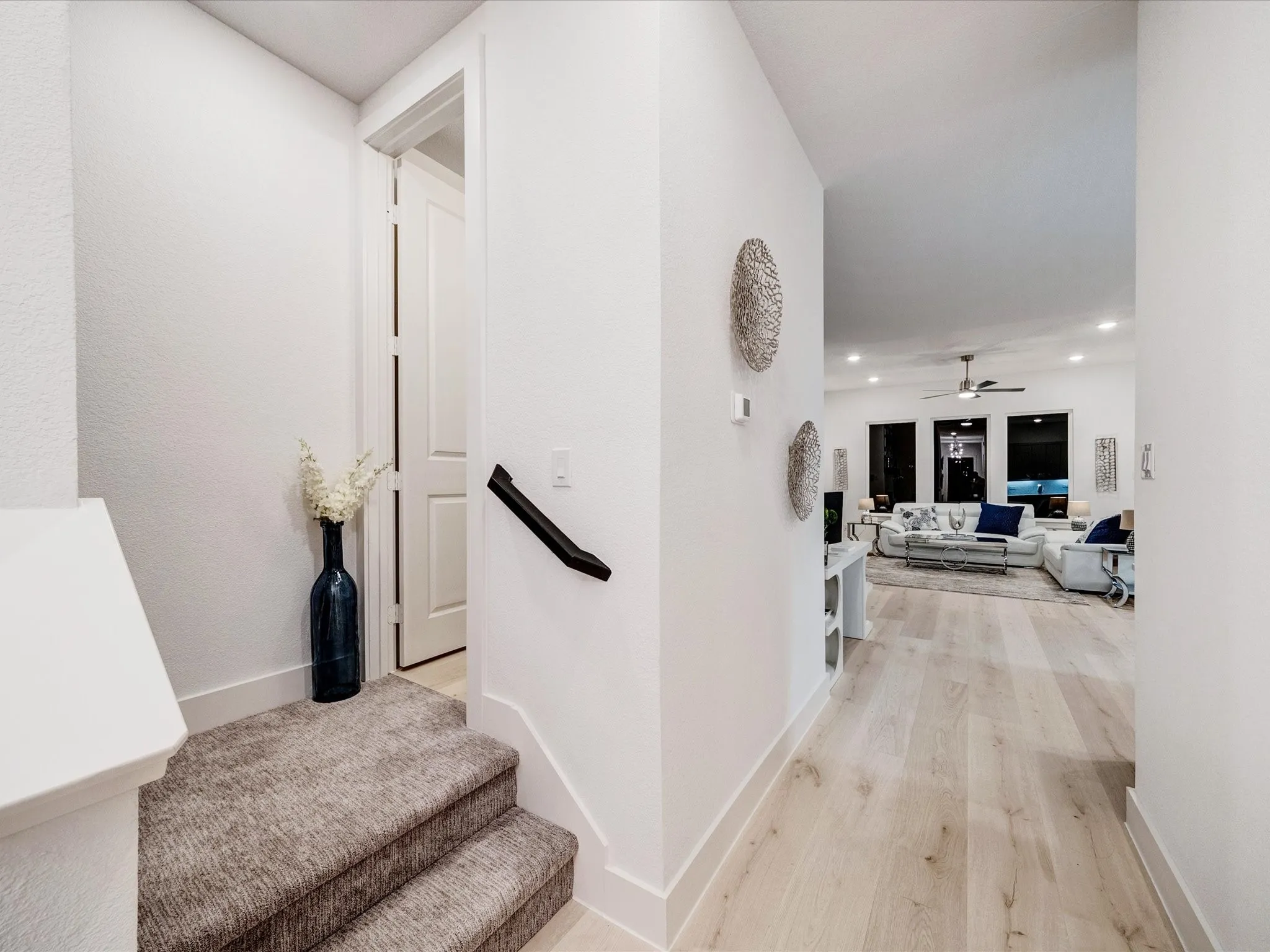 Hall with light wood finished floors and recessed lighting