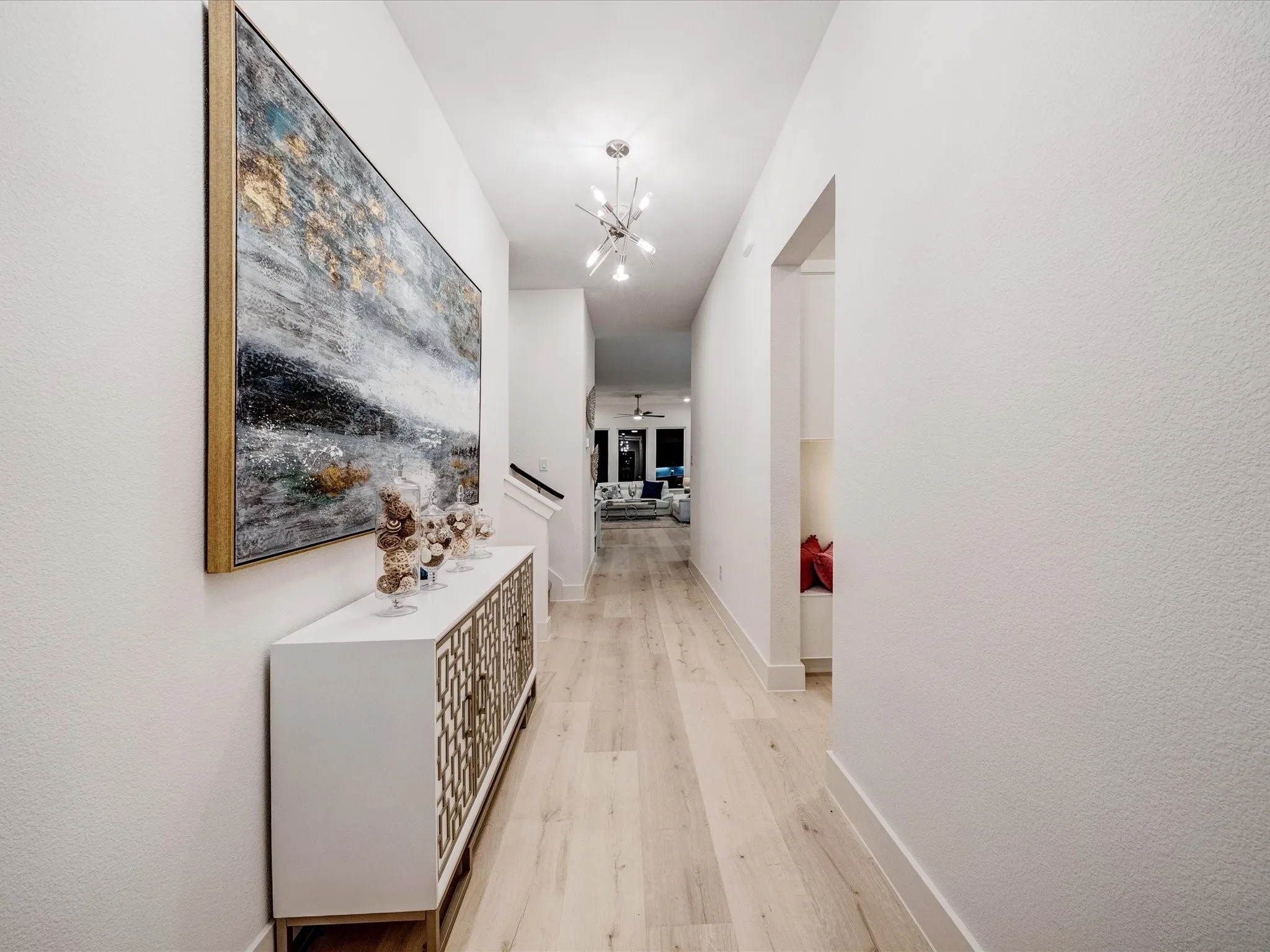 Corridor featuring light wood-type flooring and a chandelier