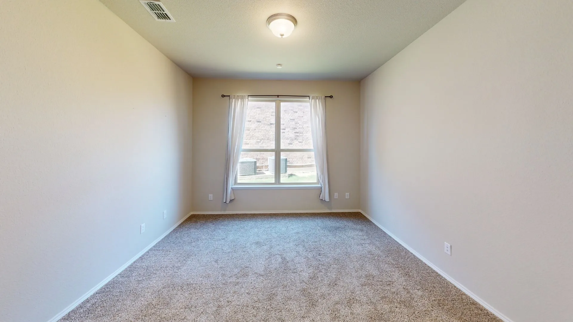 Neutral wall paint, carpet flooring, window with exterior landscape, and ceiling-mounted light fixture