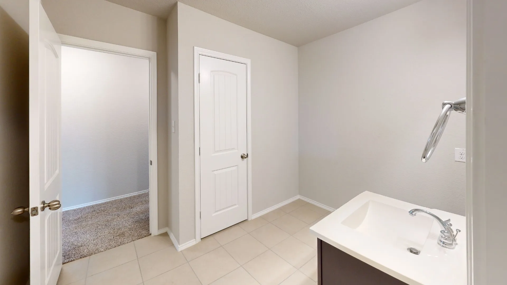 Vanity with integrated sink, chrome faucet, and dark wood-finish cabinetry