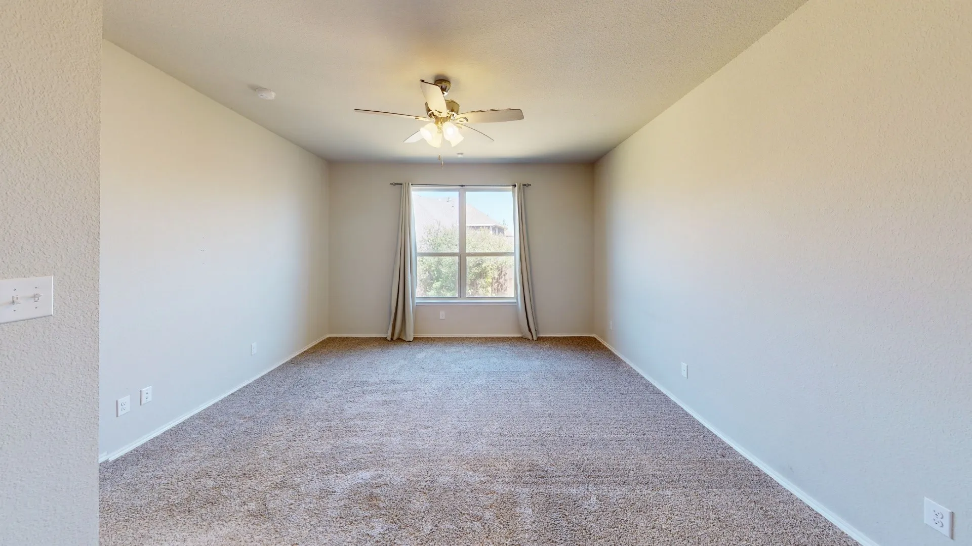 Recessed lighting, ceiling fan, neutral carpet, window with curtains, and textured walls