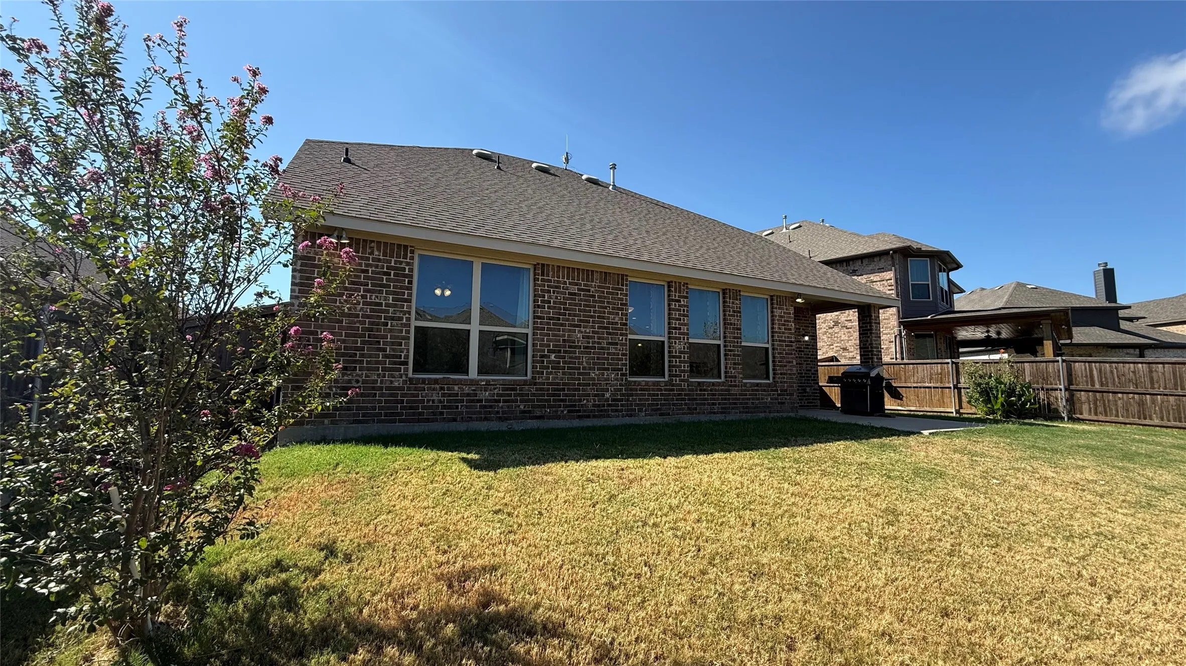 Brick exterior with multiple windows and a covered patio area