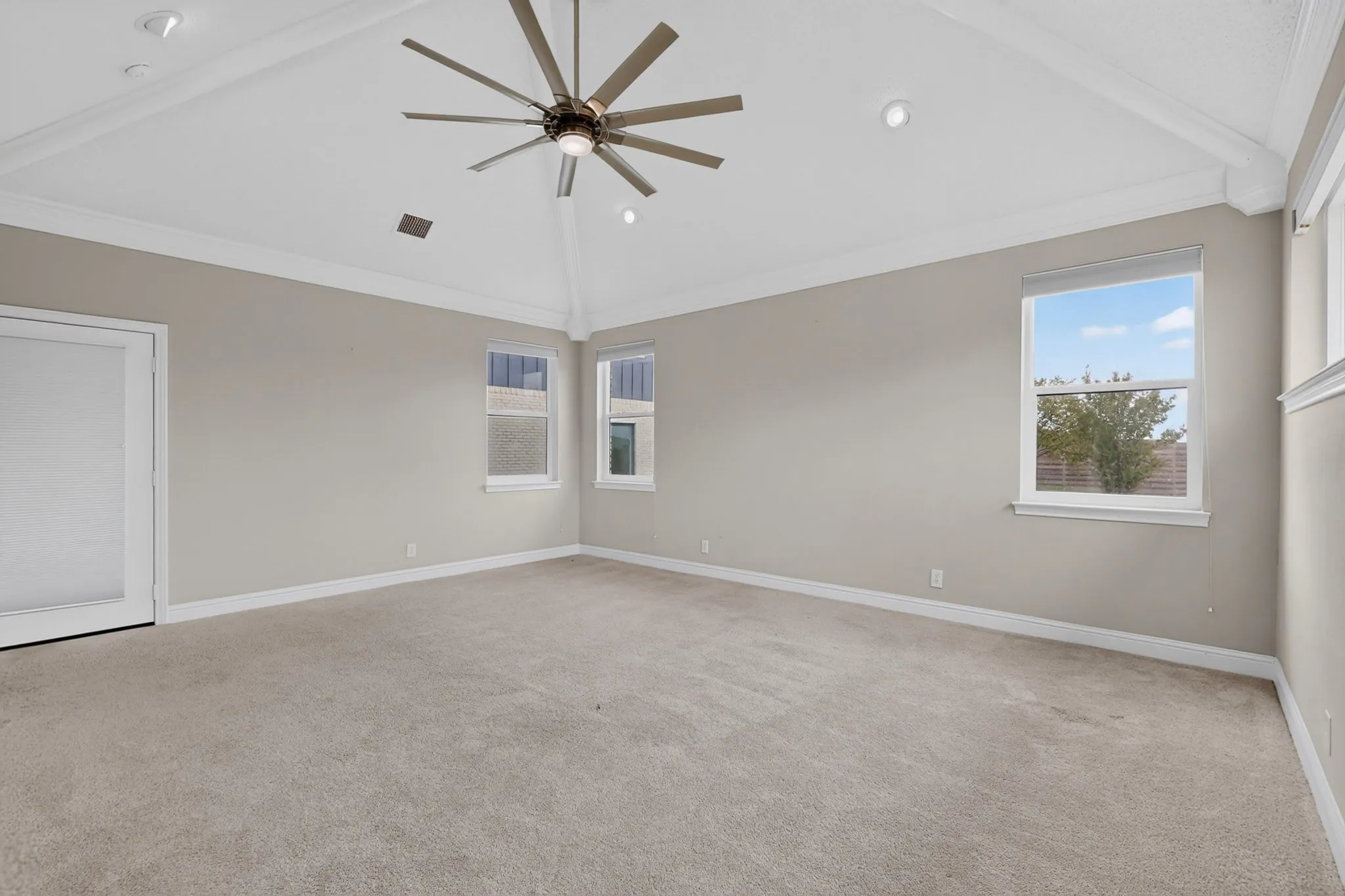 Vaulted ceiling with recessed lighting and a large ceiling fan