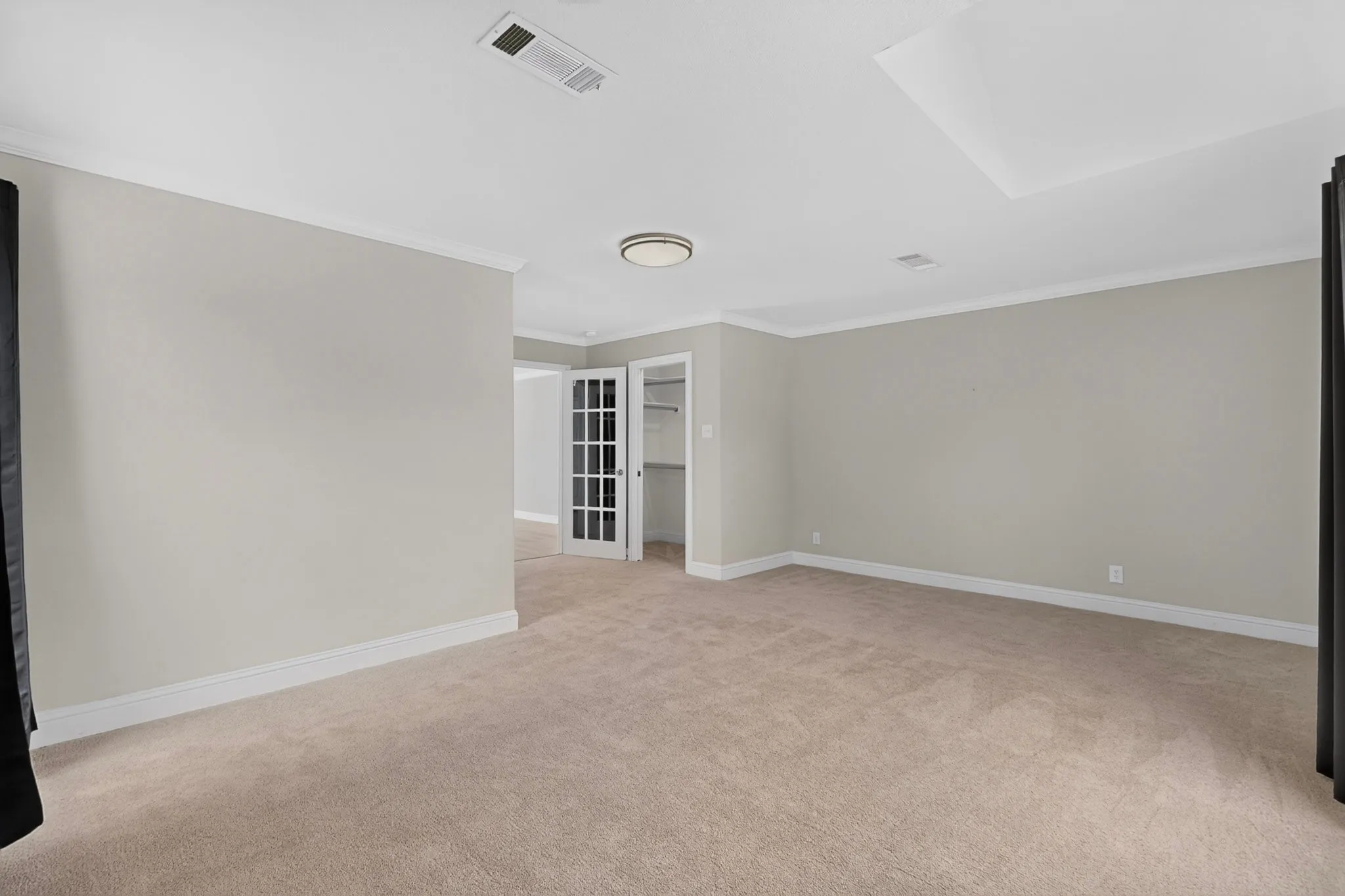 Carpeted flooring, crown molding, white trim, recessed ceiling detail, and French doors