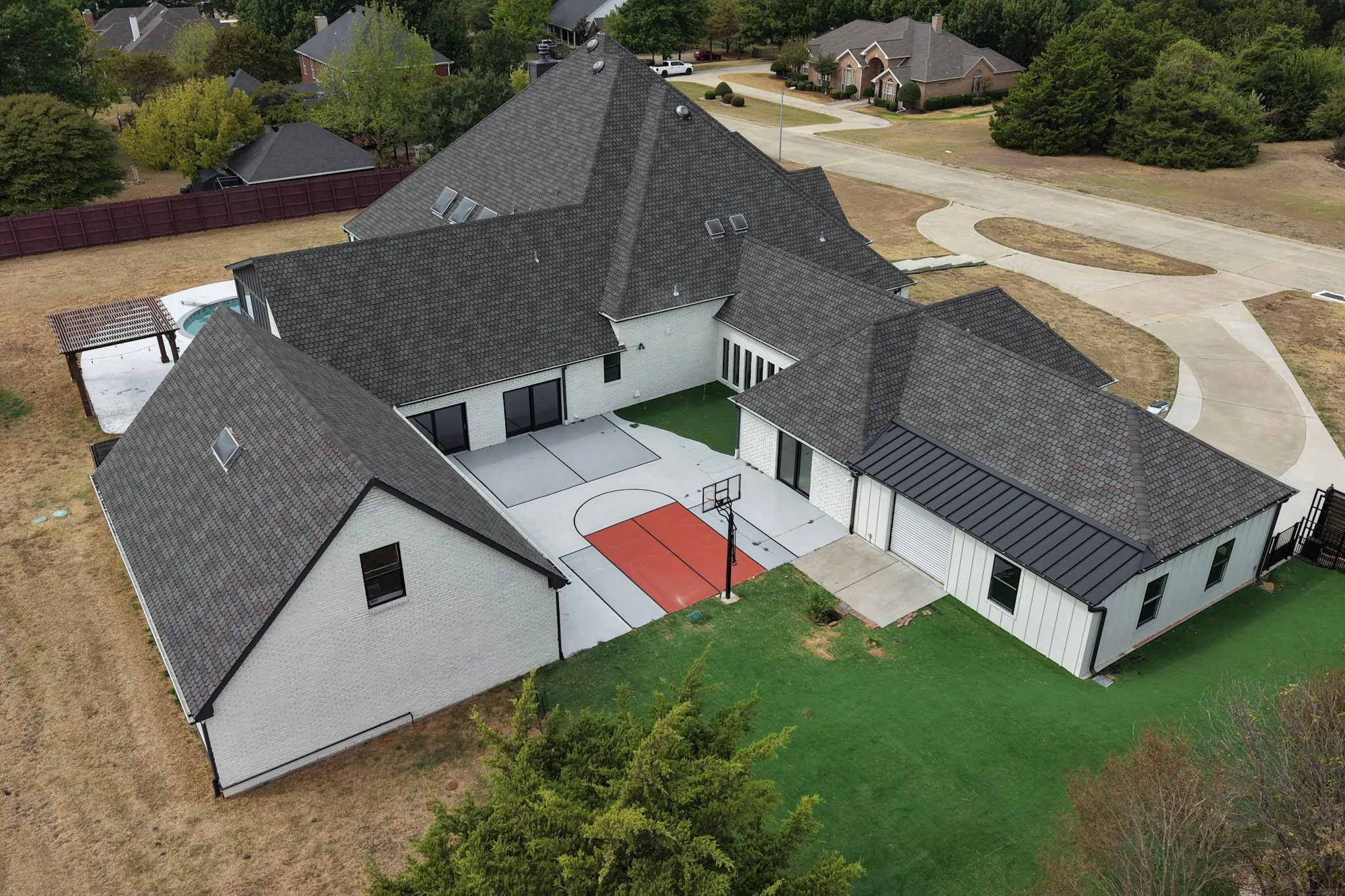 Spacious property featuring a large patio, built-in basketball court, and turf lawn