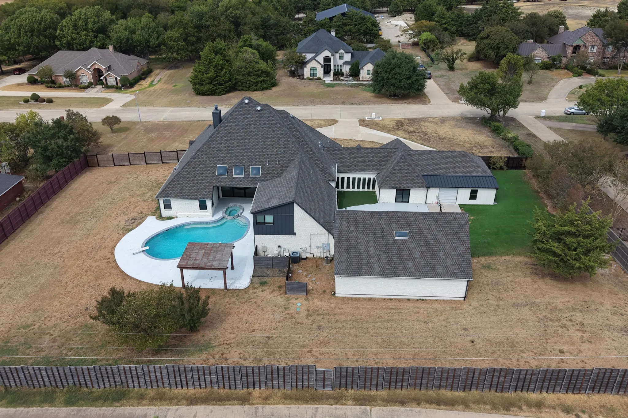 Modern residence with multiple rooflines, a private swimming pool, and an attached garage structure
