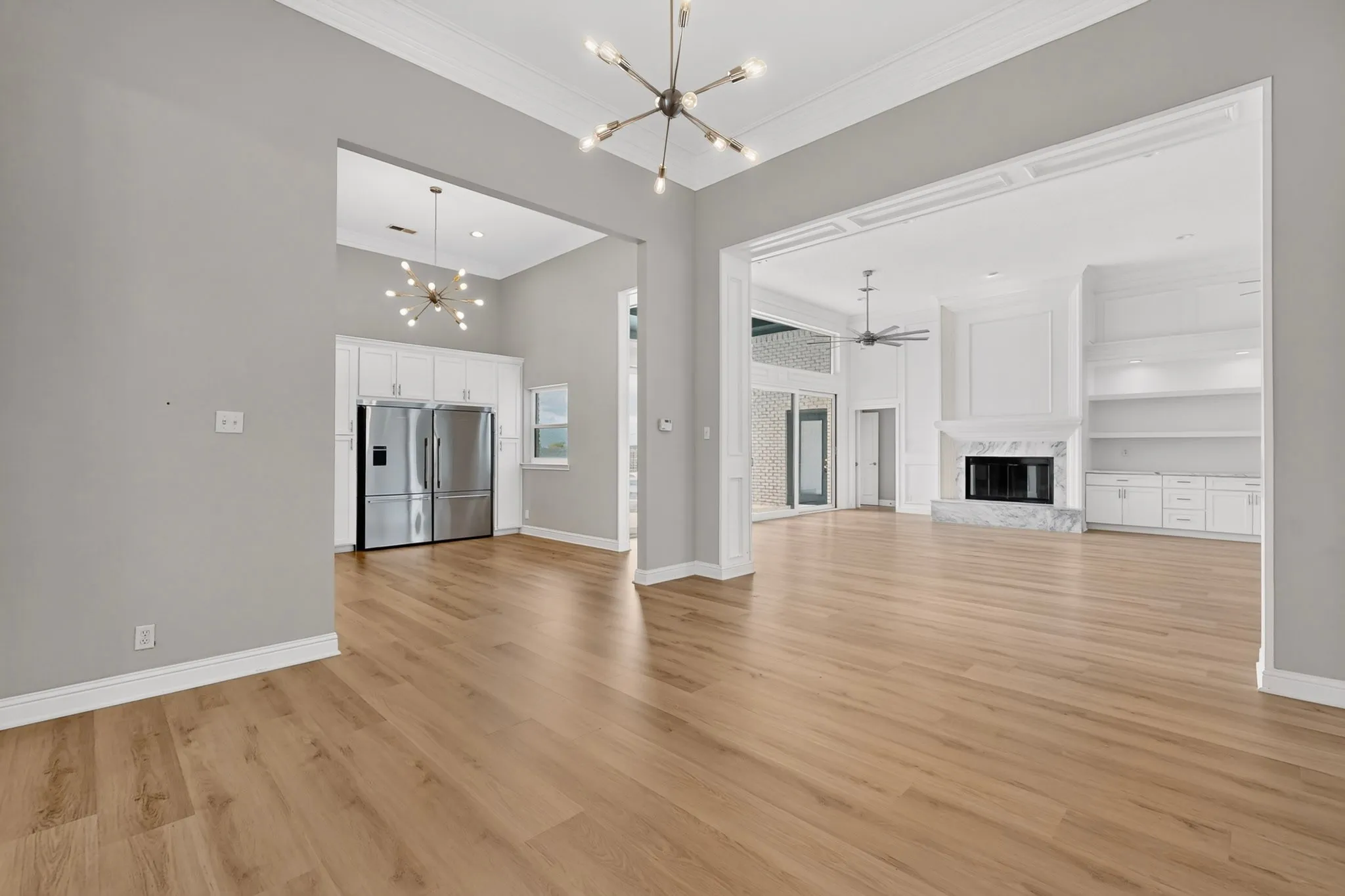 Vaulted ceilings, wood-finish flooring, stainless steel appliances, built-in shelving, and a fireplace with stone surround