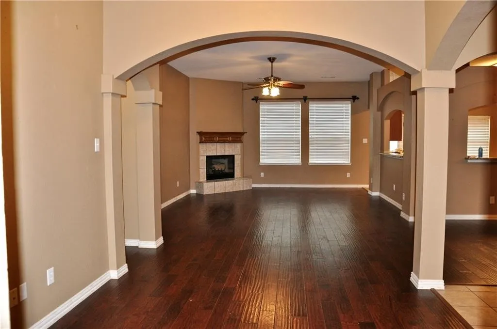 Bright and open family room featuring a cozy corner fireplace and seamless flow into the kitchen