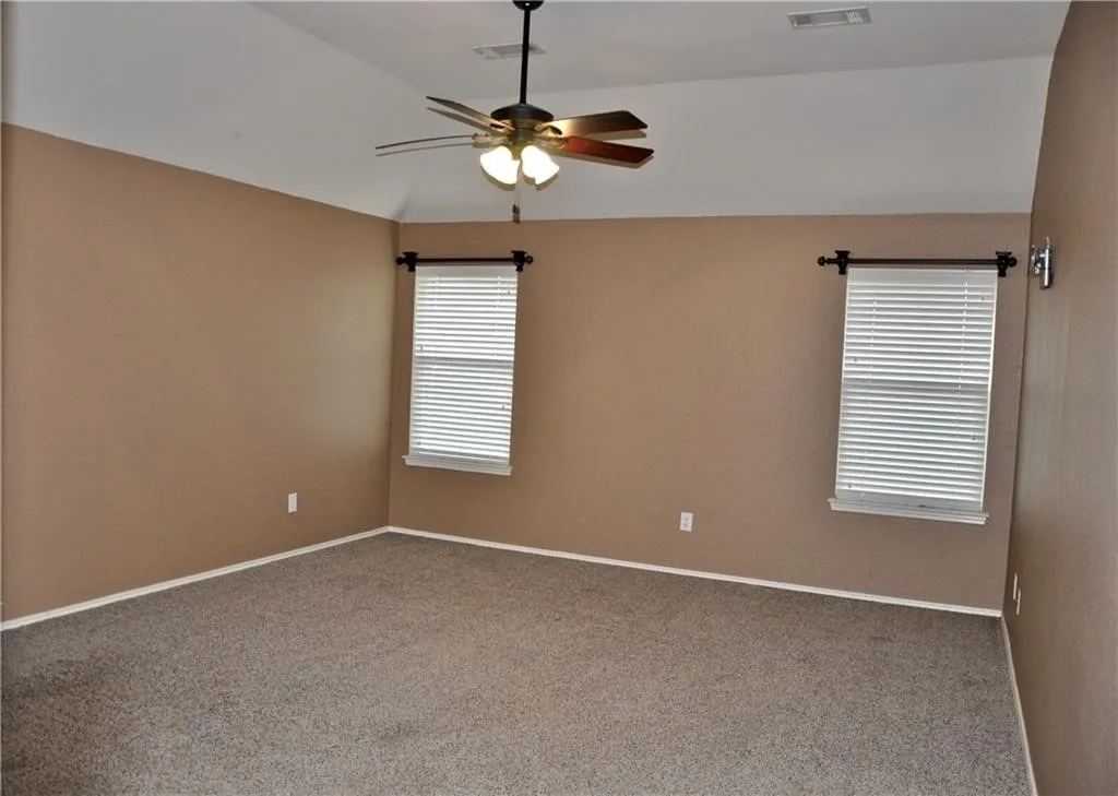 Generously sized Primary bedroom complete with a ceiling fan, carpeting, and great natural light