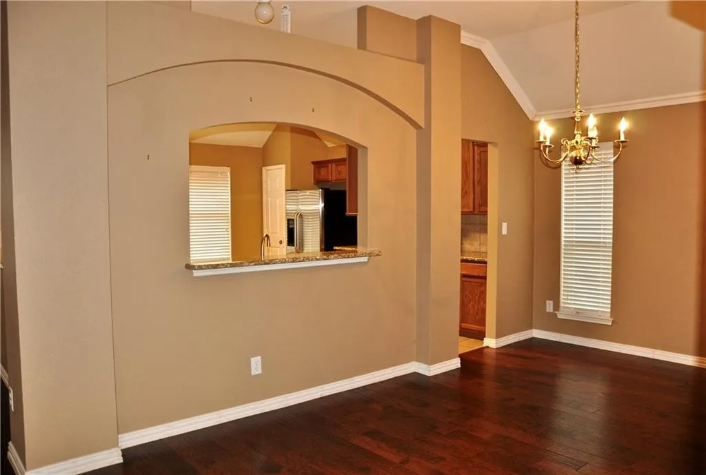 Dedicated dining space featuring a classic chandelier and a convenient pass-through cutout to the kitchen.
