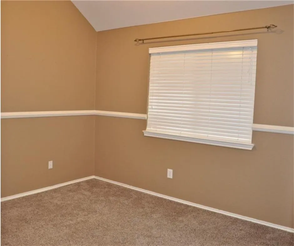 Additional bedroom showcasing elegant chair rail molding accents and neutral warm tones throughout