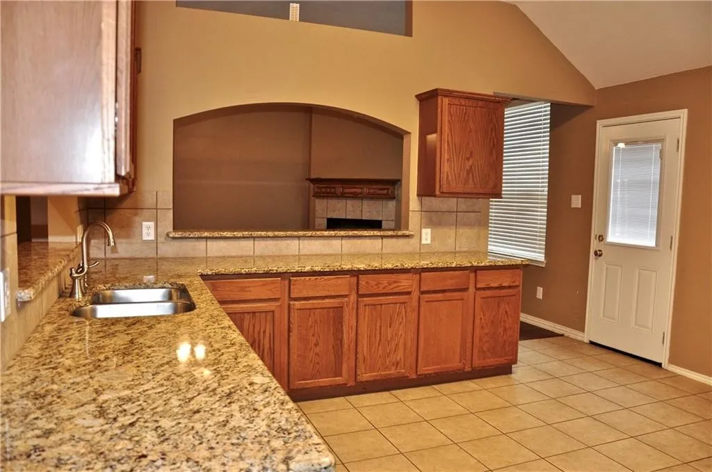 Functional L-shaped kitchen featuring a breakfast bar ledge that opens directly to the main living areas