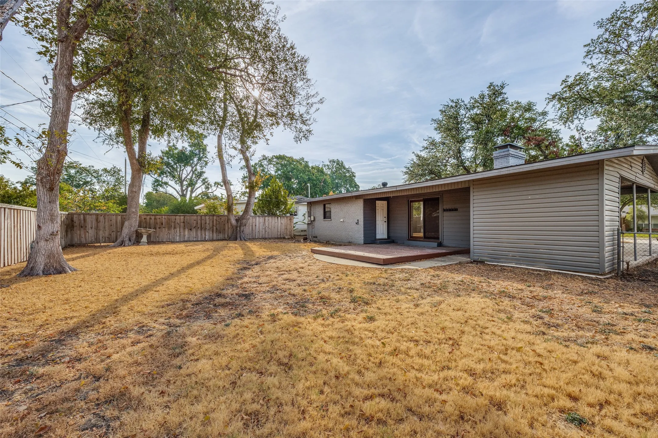 Expansive backyard featuring mature trees, wood privacy fencing, and a built-in outdoor​​‌​​​​‌​​‌‌​‌‌​​​‌‌​‌​‌​‌​​​‌​​ deck
