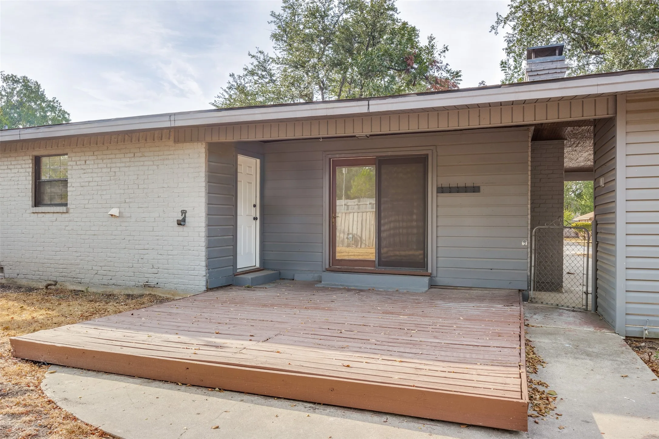 Wood deck patio with a sliding glass door and an exterior door
