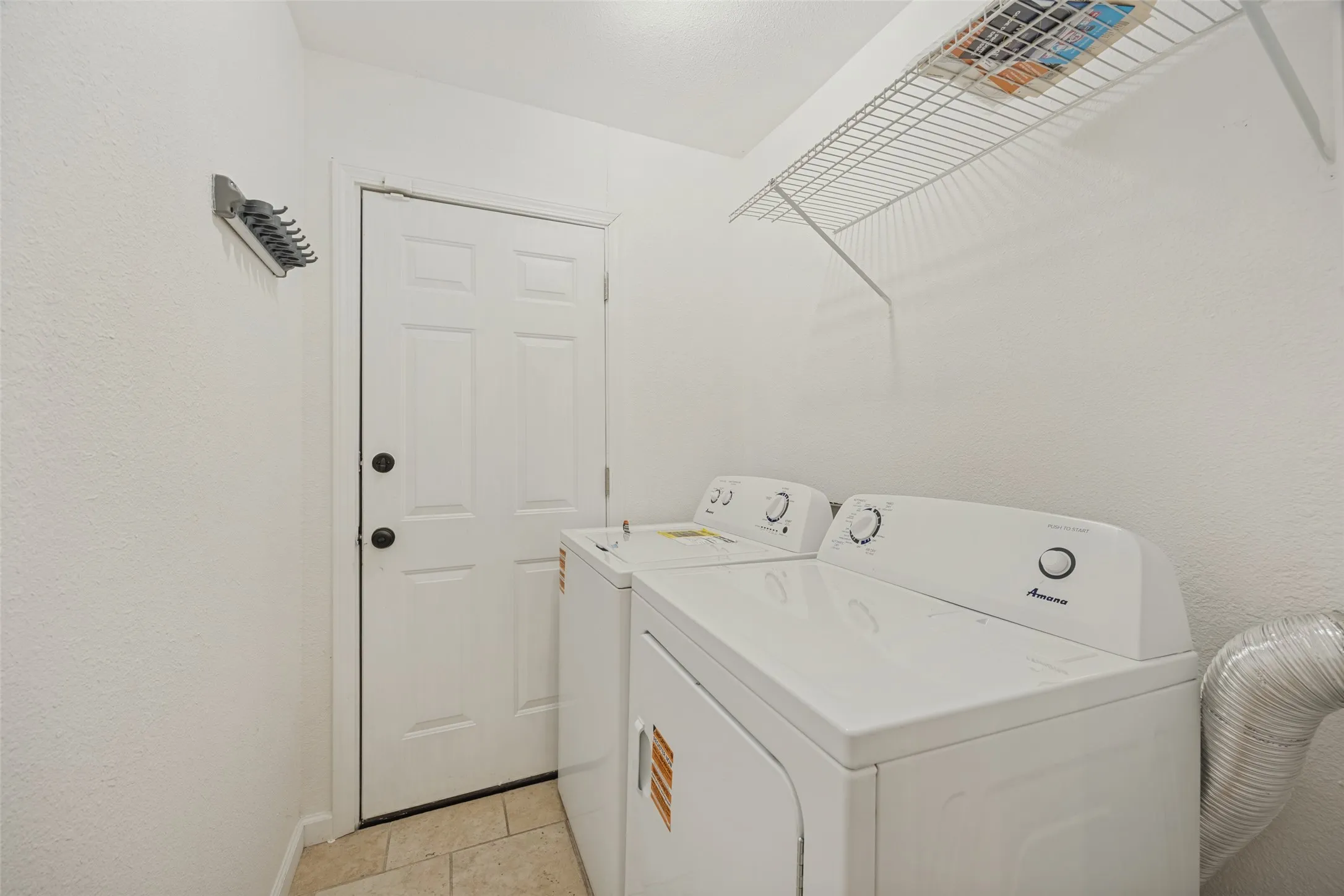 White paneled door, wire shelving, and tile flooring
