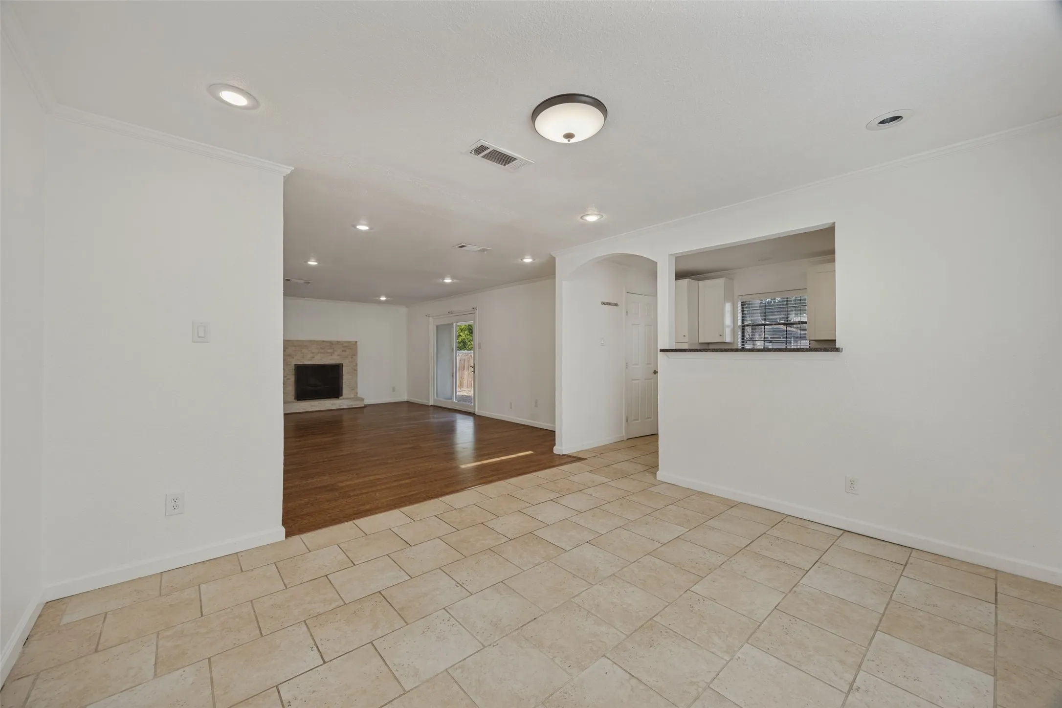 Recessed lighting, arched doorway, tile flooring, wood-finish flooring, stone fireplace