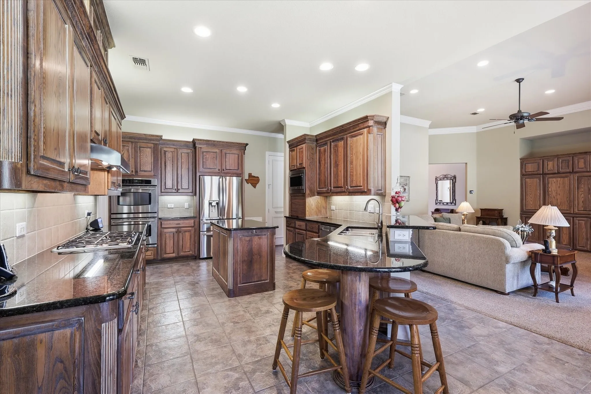 Full kitchen featuring wood cabinetry, stainless steel appliances, and dark countertops