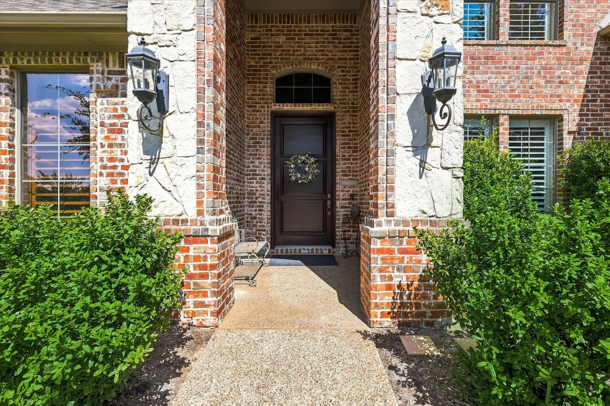 Brick and stone facade with decorative sconce lighting