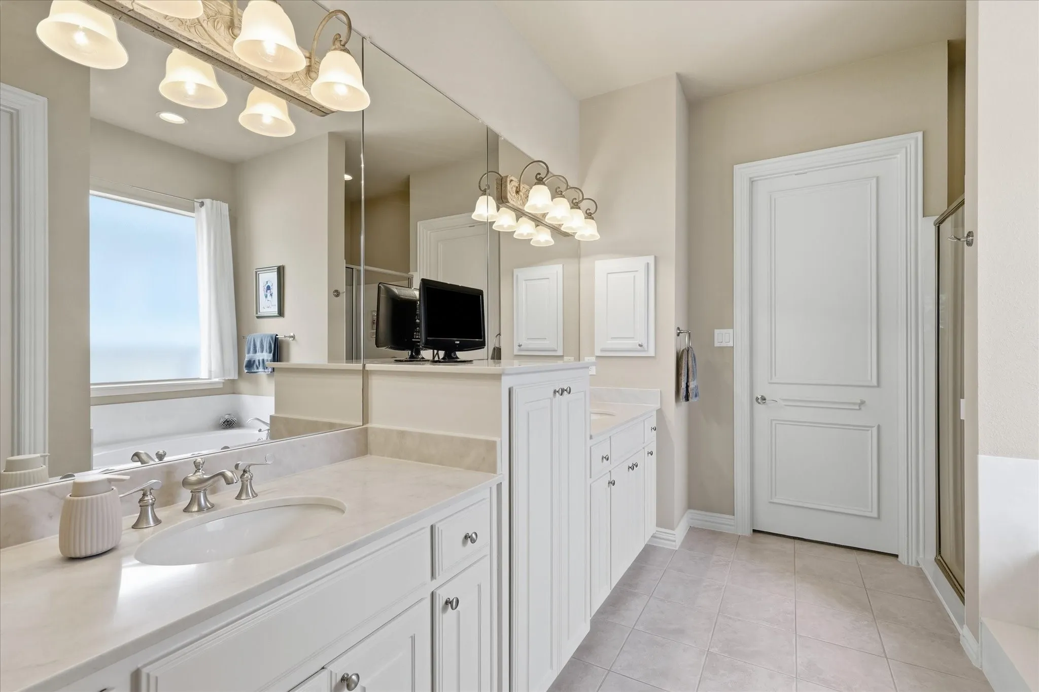 Dual vanities with undermount sinks and light-toned countertops