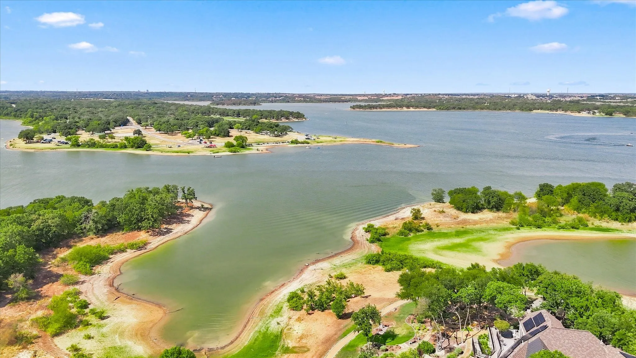 Expansive body of water with surrounding treed land and clear skies