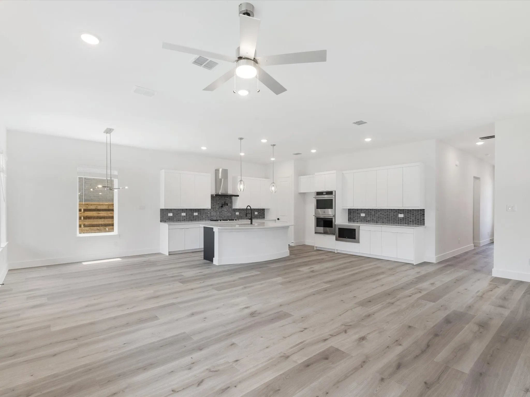 Unfurnished living room featuring light wood finished floors, ceiling fan, and recessed lighting