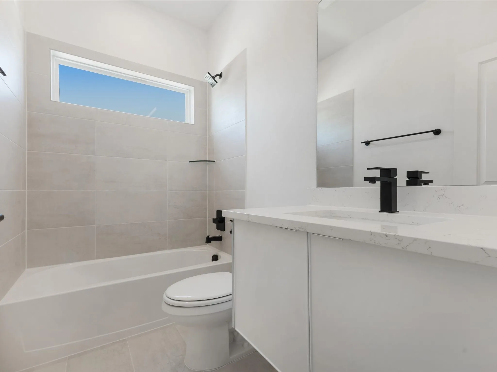 Ensuite Bathroom with tub / shower combination, vanity, and light tile patterned floors