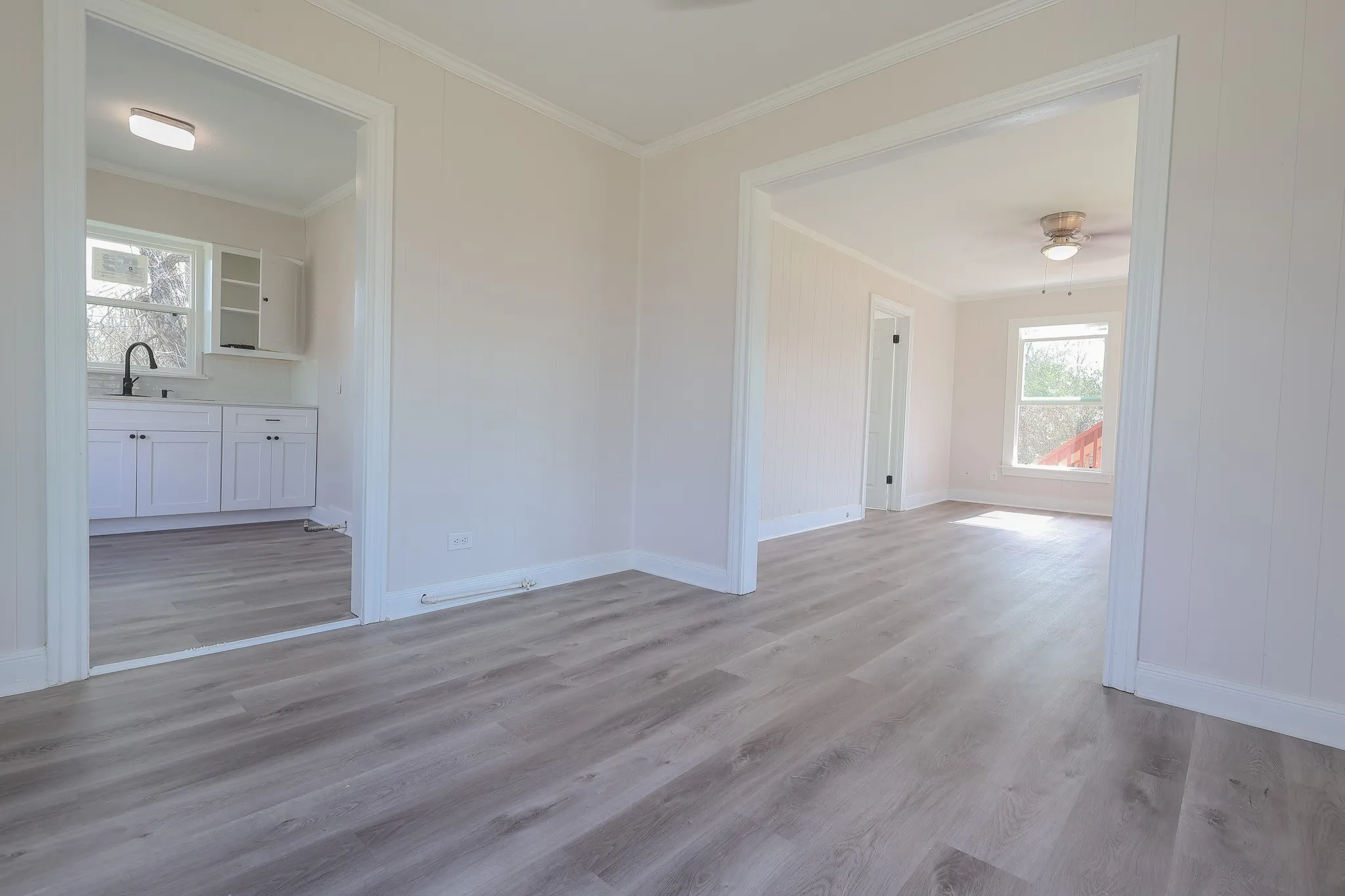 Wood-finish flooring throughout, bright white trim, and light-toned walls