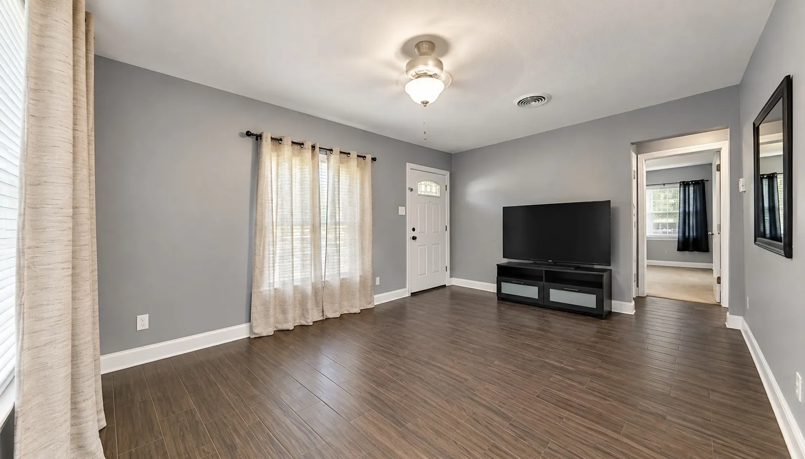Wood-finish flooring, neutral gray walls, and white trim