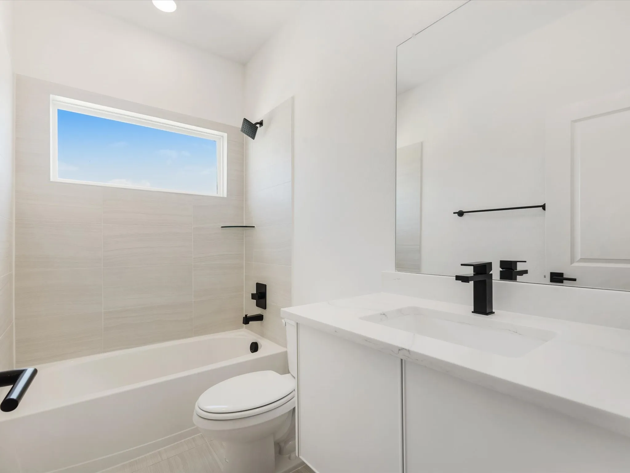 Ensuite bath featuring bathing tub / shower combination, vanity, and light tile patterned flooring