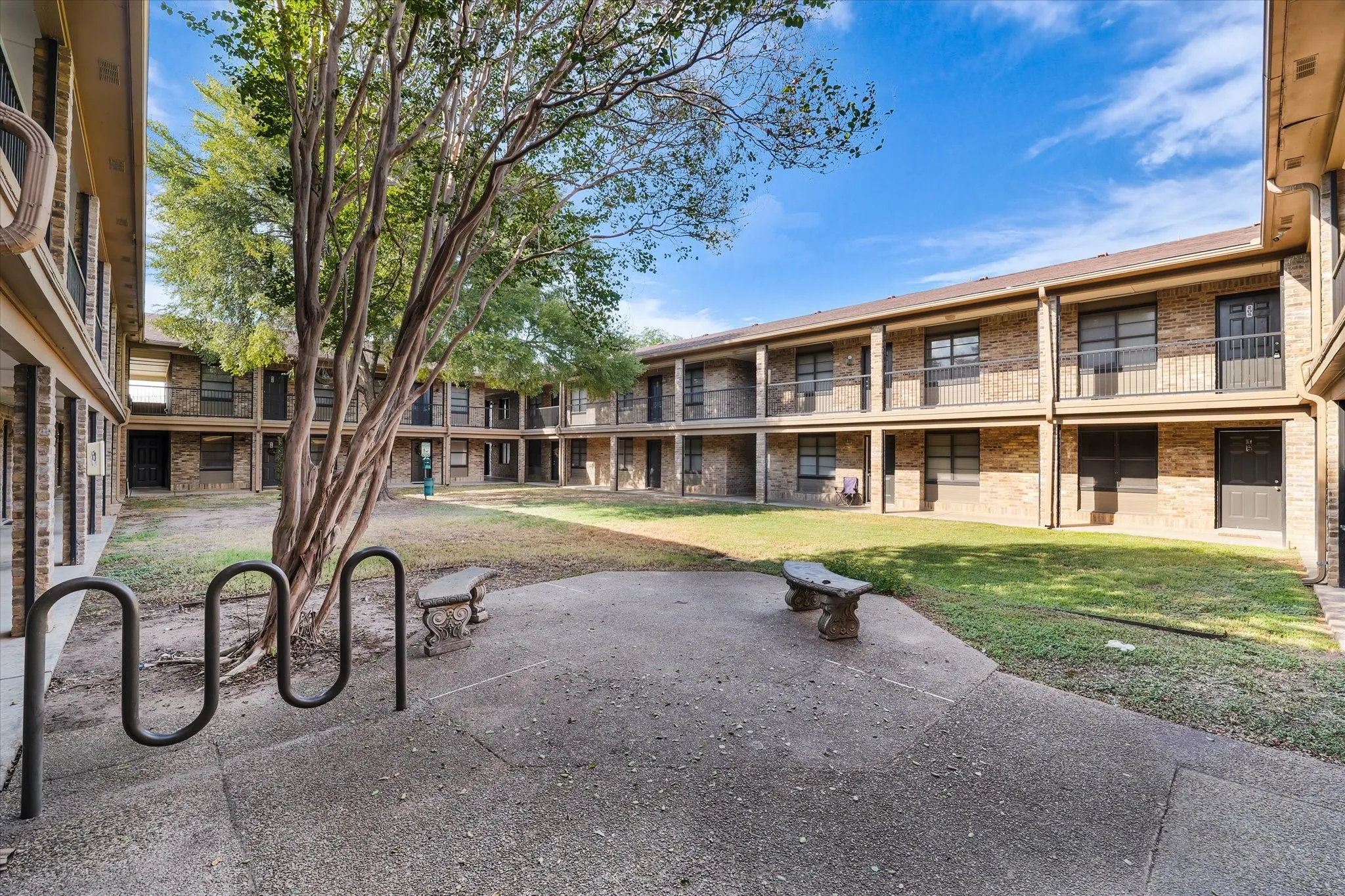 Central courtyard with mature tree, concrete pathways, and green space