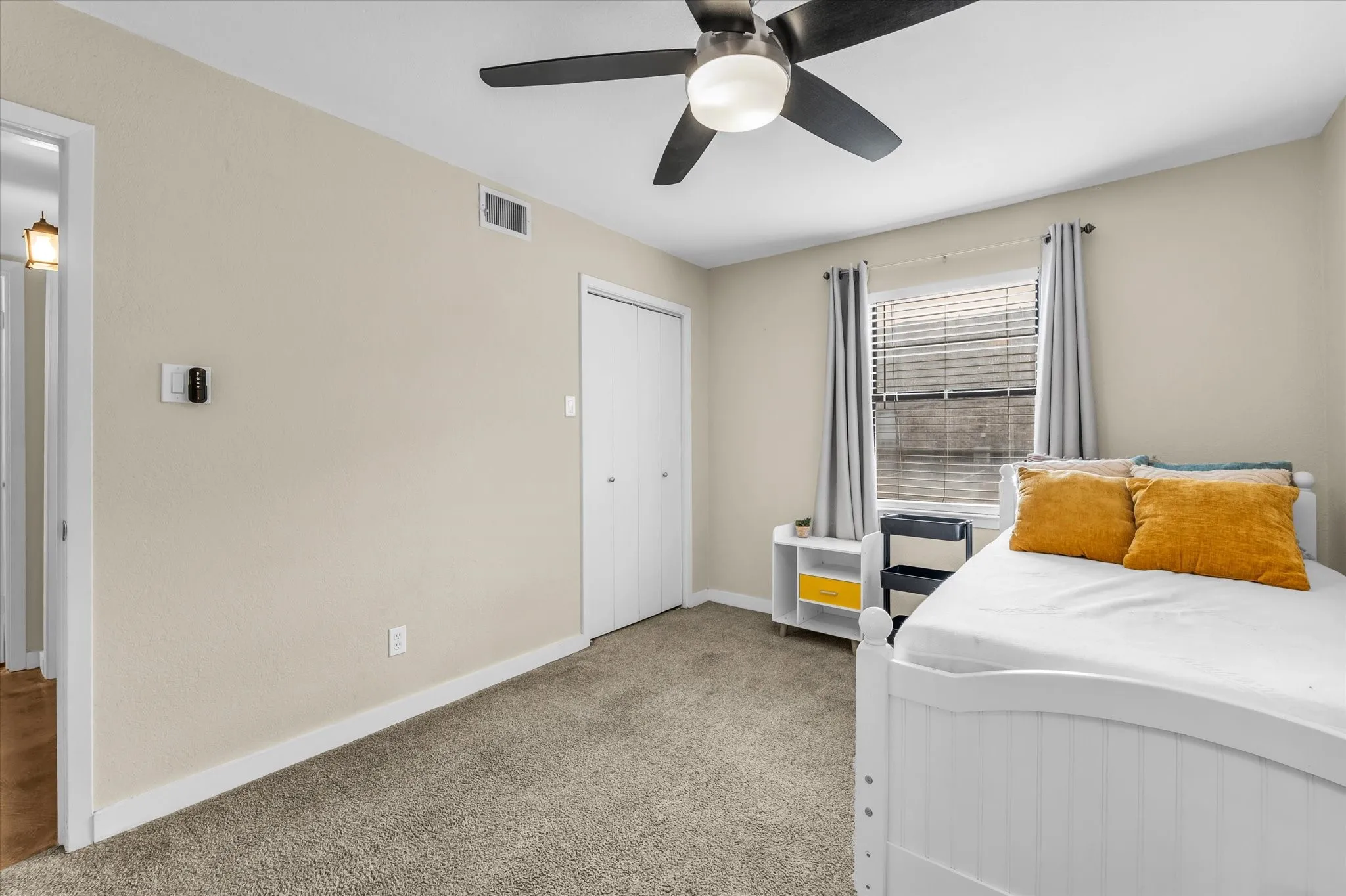 Recessed window with blinds, ceiling fan with integrated lighting, built-in closet with bi-fold doors, and neutral wall paint