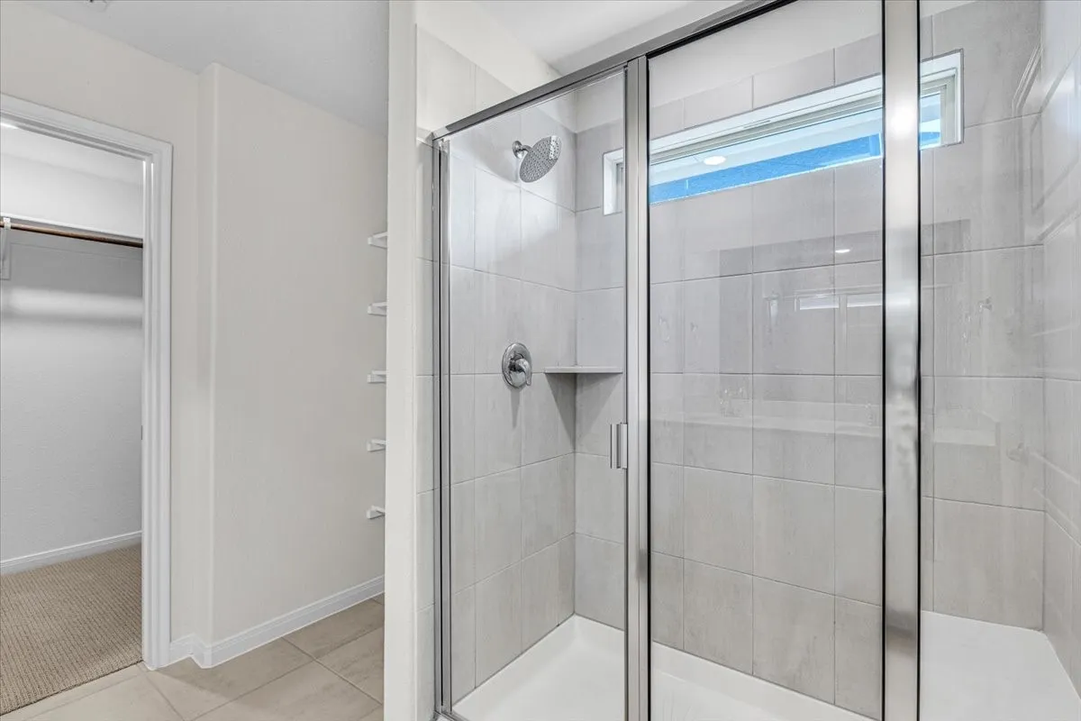 Another view of the elegant master bathroom with large shower with bench