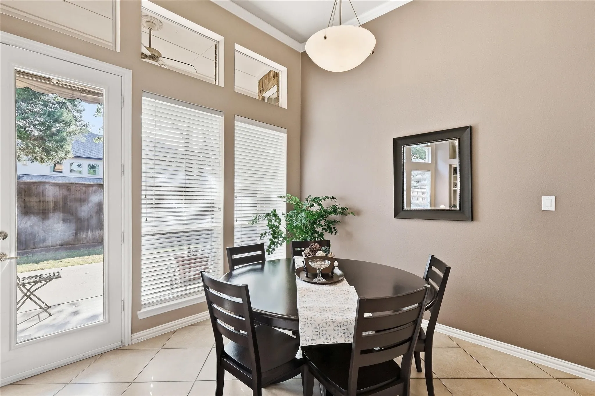 Open concept living space featuring high ceilings, crown molding, arched entryways, tile flooring, and a ceiling fan with integrated lighting