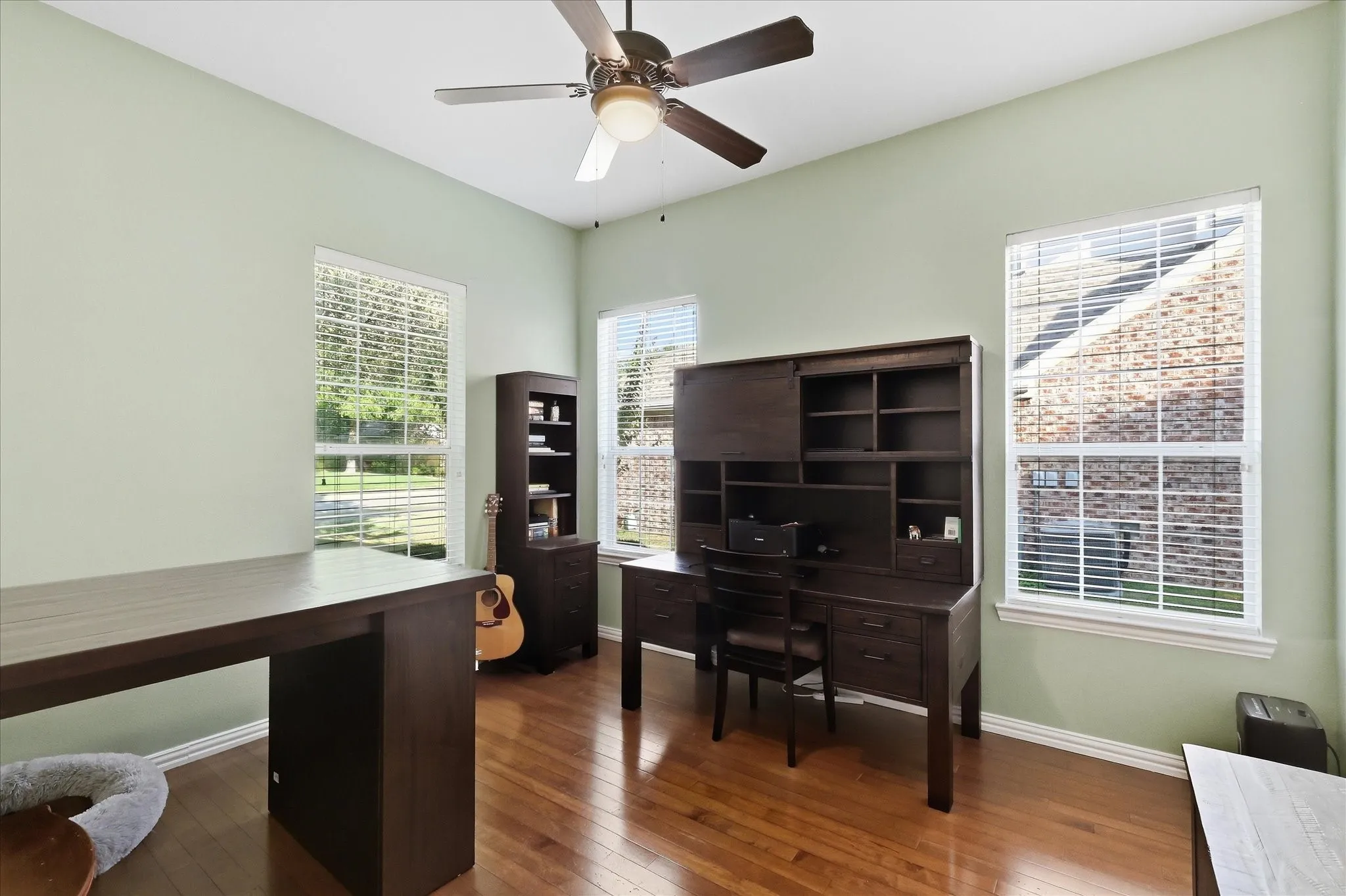Hardwood-finish flooring, high vaulted ceiling, and multiple windows with blinds