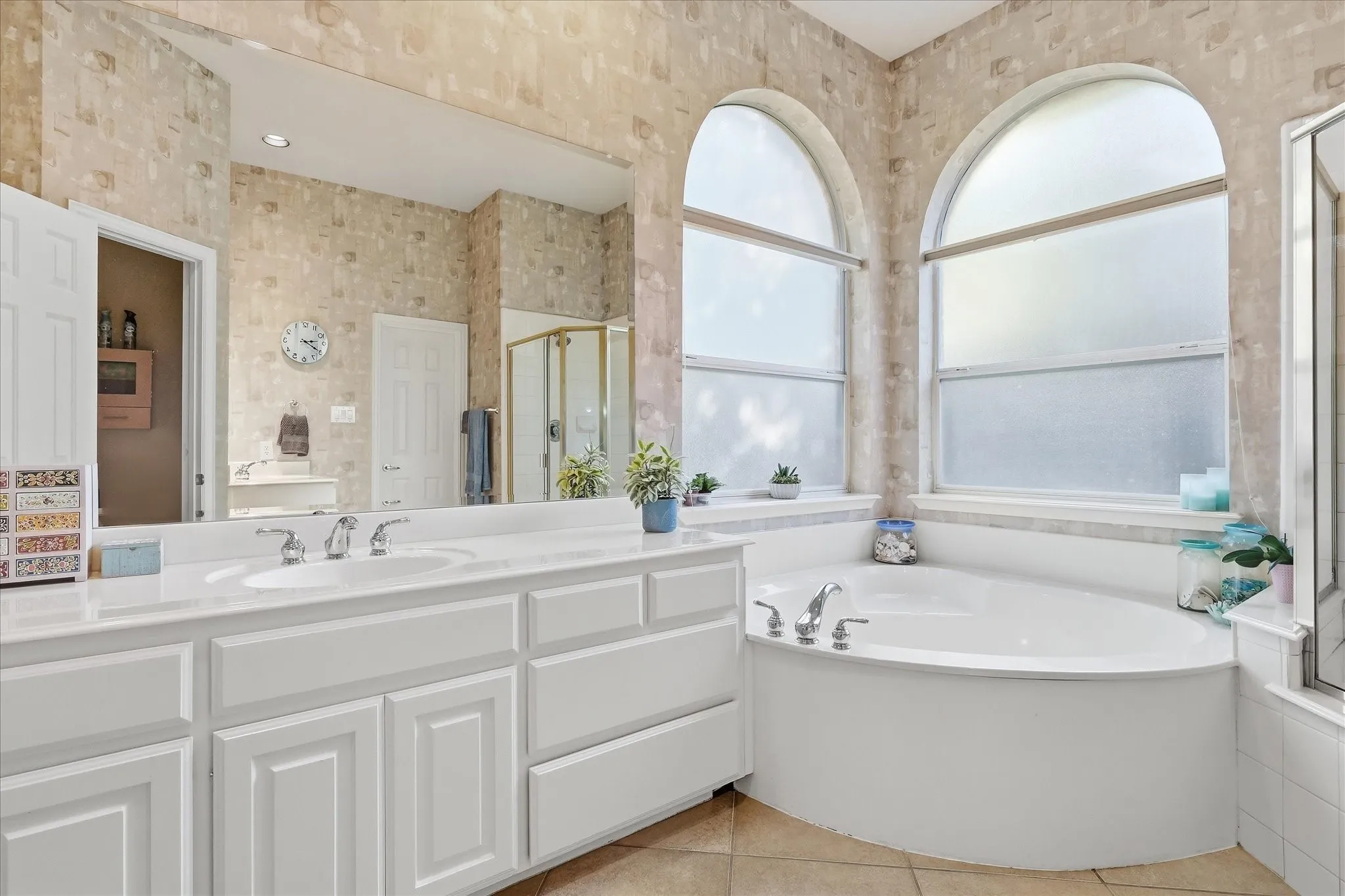 High vaulted ceiling with a ceiling fan, bay window configuration with multiple windows, light-colored carpeting, and white painted walls
