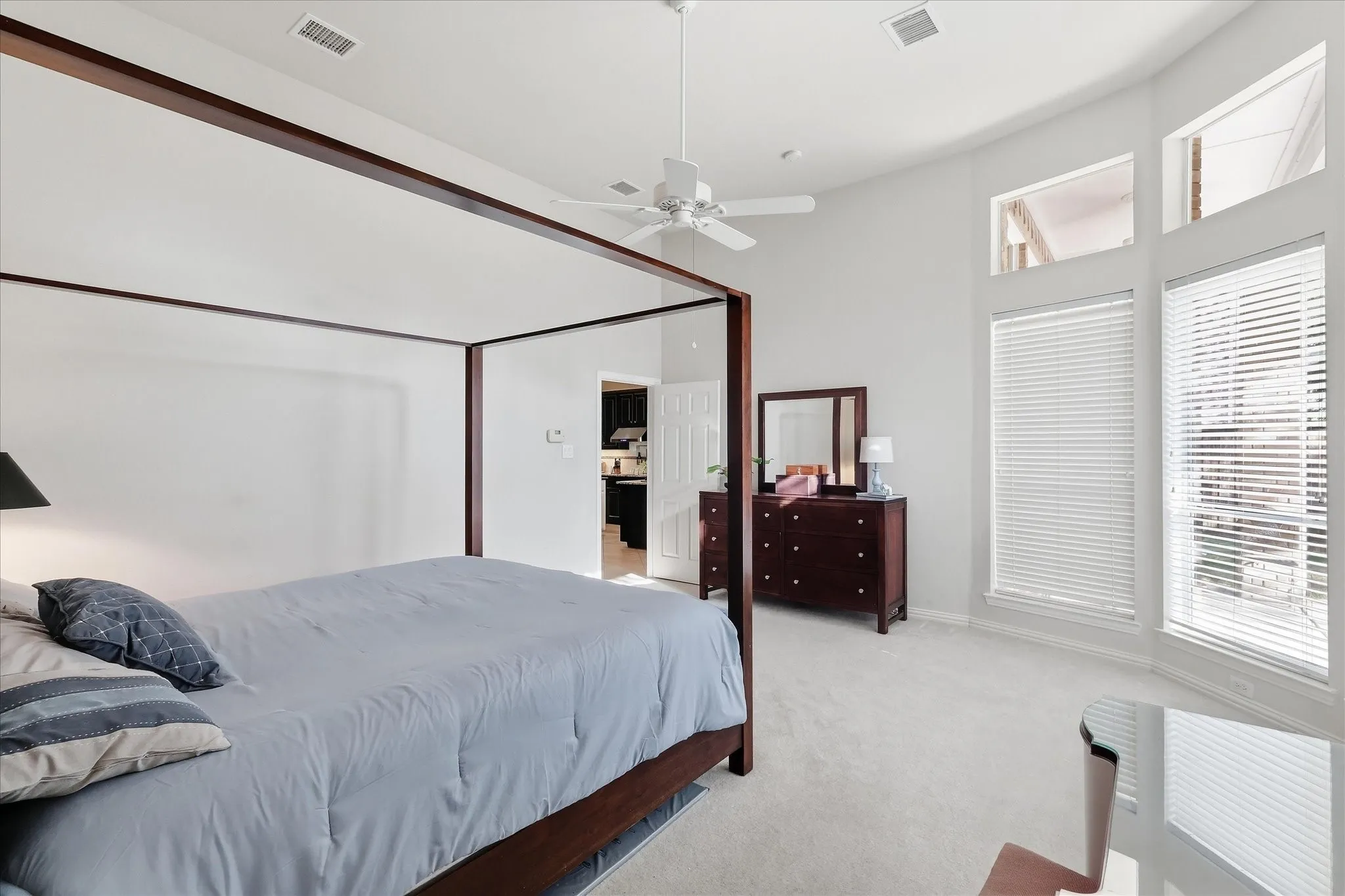 Vaulted ceiling with a flush-mount light fixture, transom windows, full-lite glass door, and tiled flooring