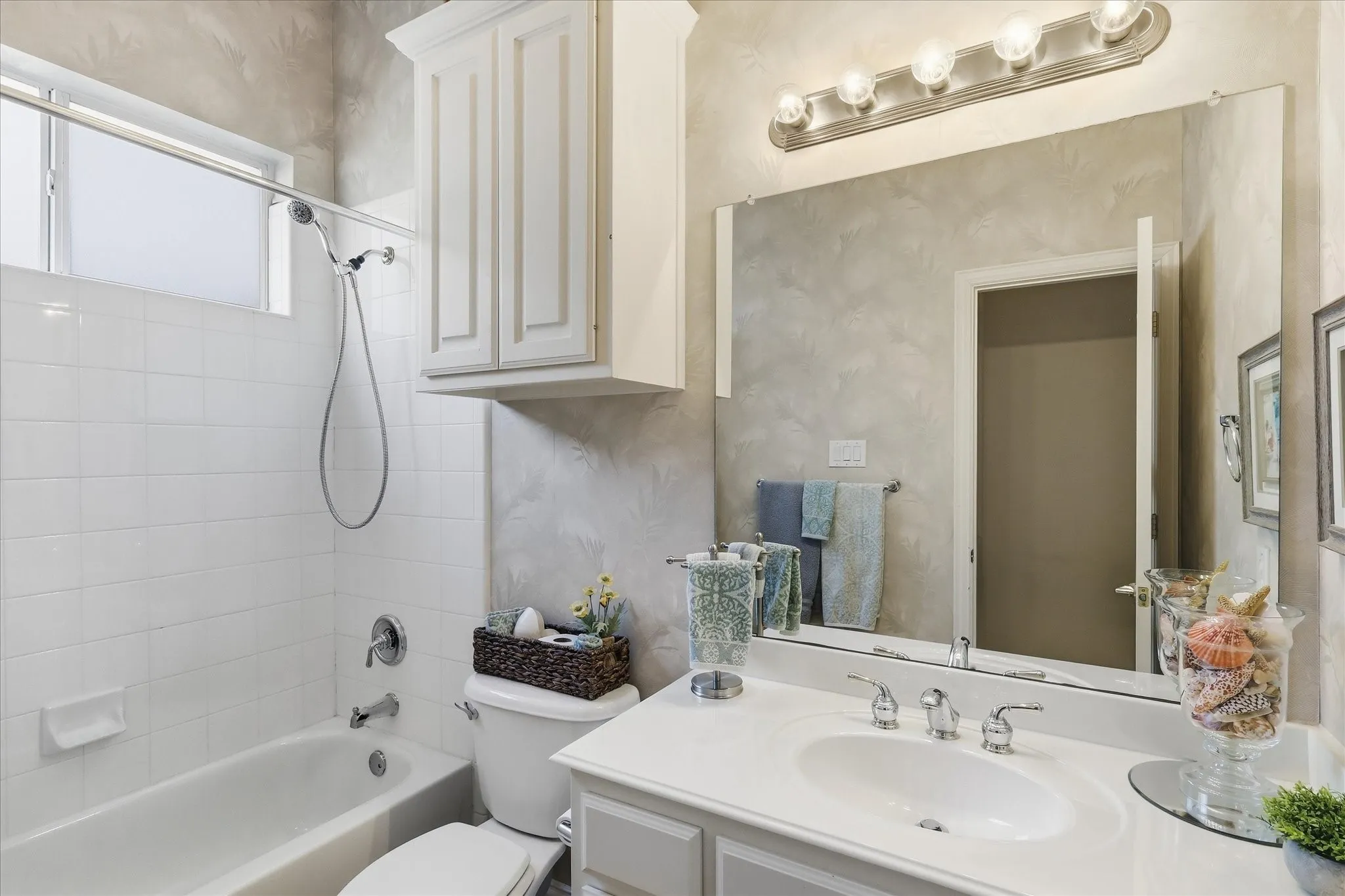 White tile tub and shower combination with a shower window